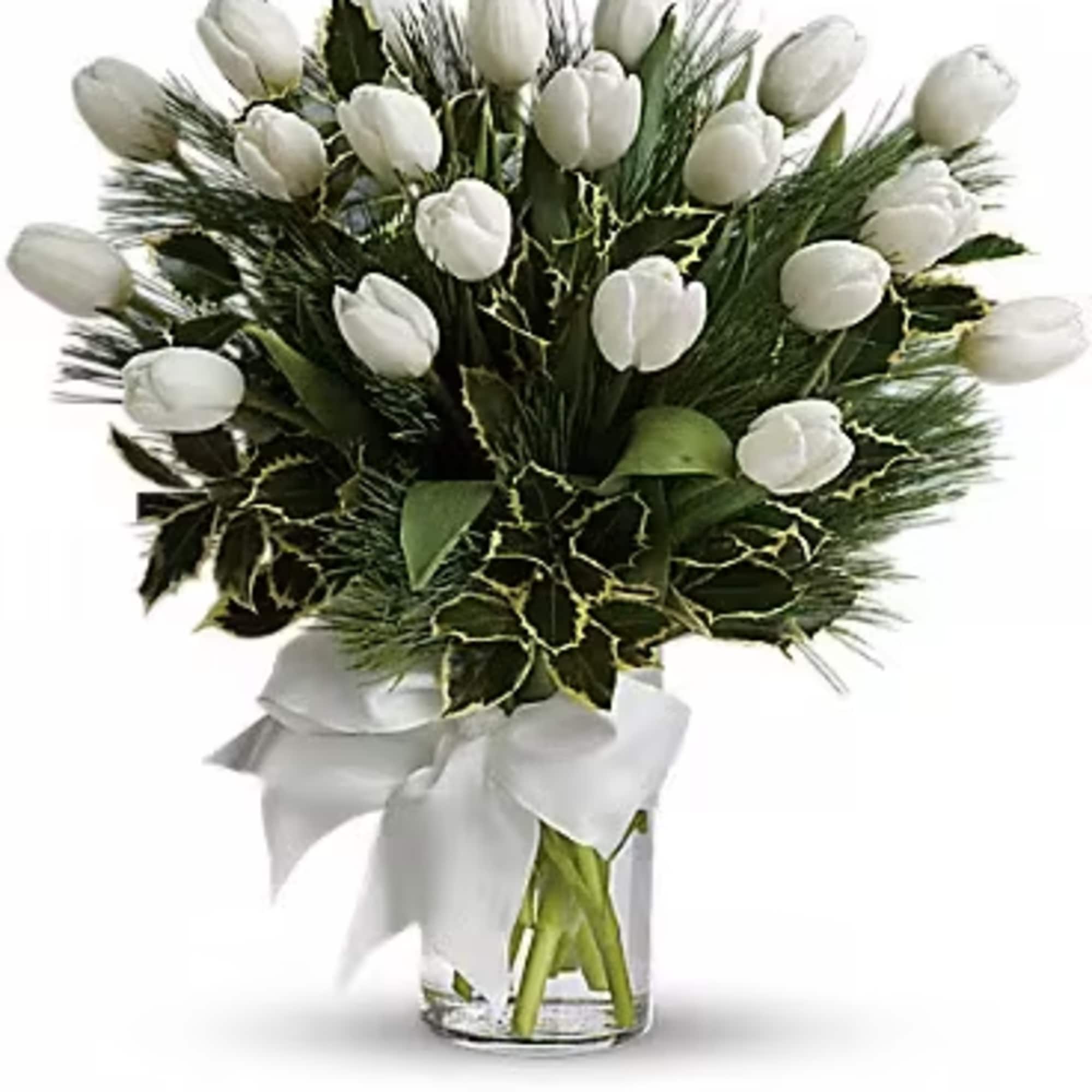 White tulips arranged in a clear glass vase with a white ribbon