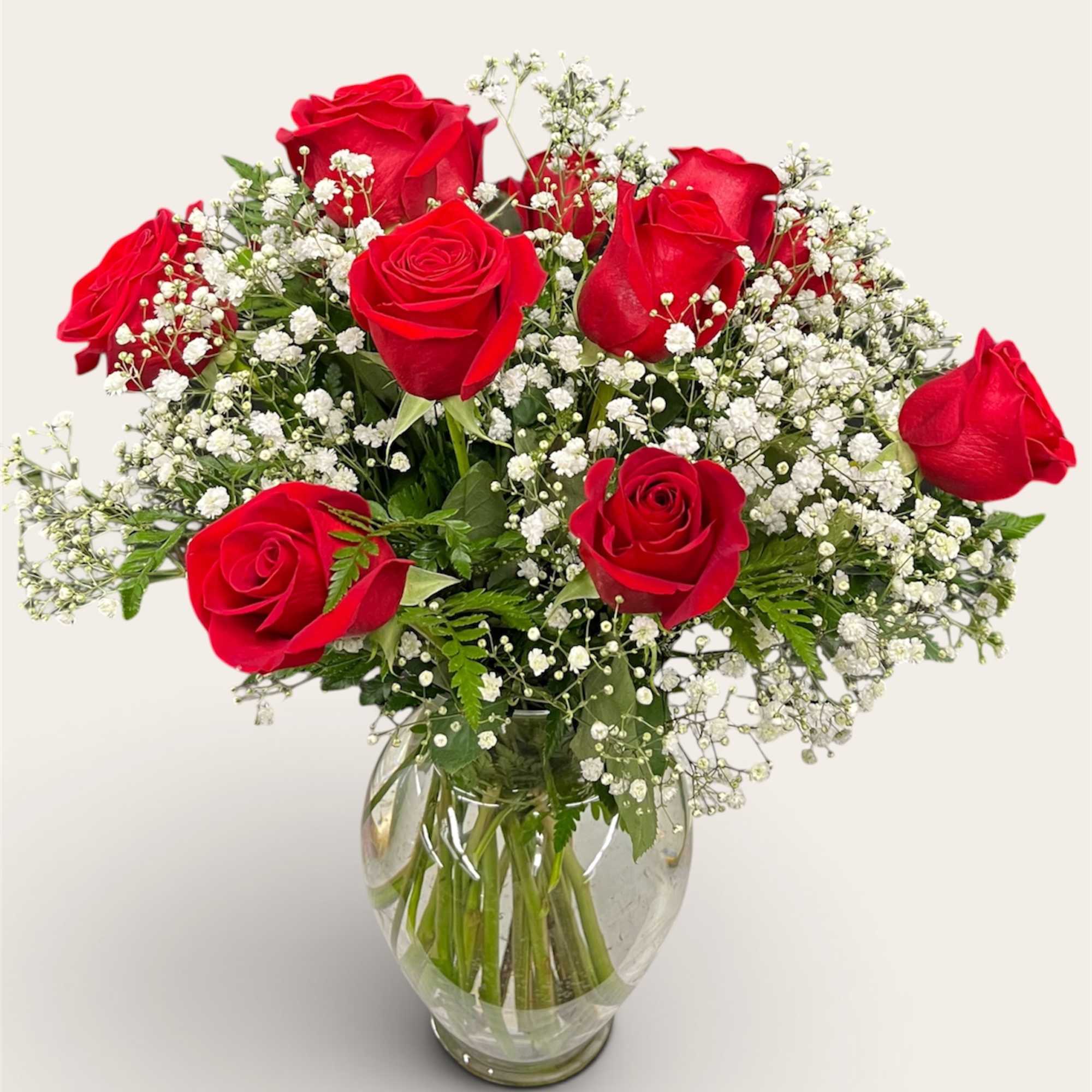 Red roses and baby's breath in a clear glass vase
