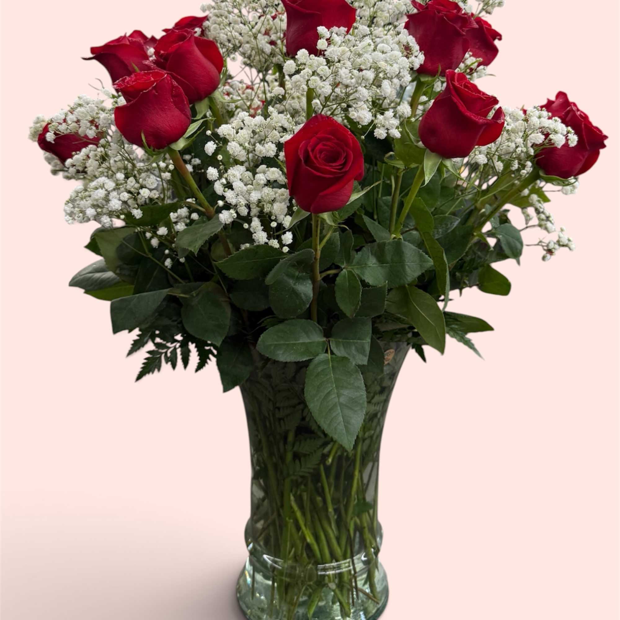 Red roses and white baby's breath in a clear glass vase