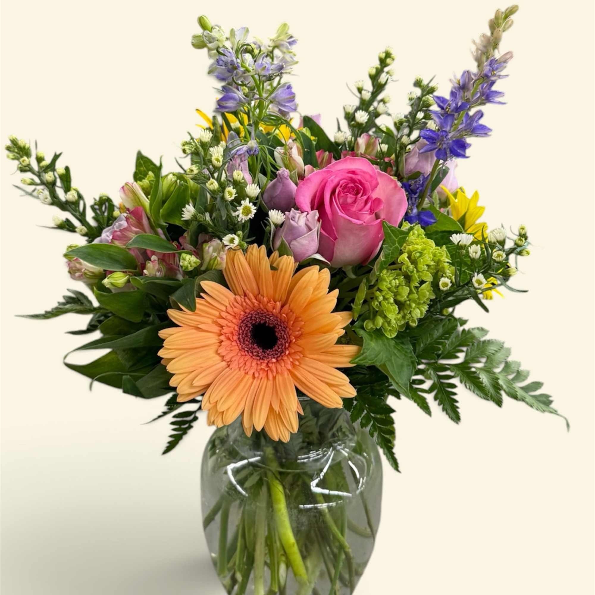 Mixed bouquet in a clear glass vase with pink and orange blooms