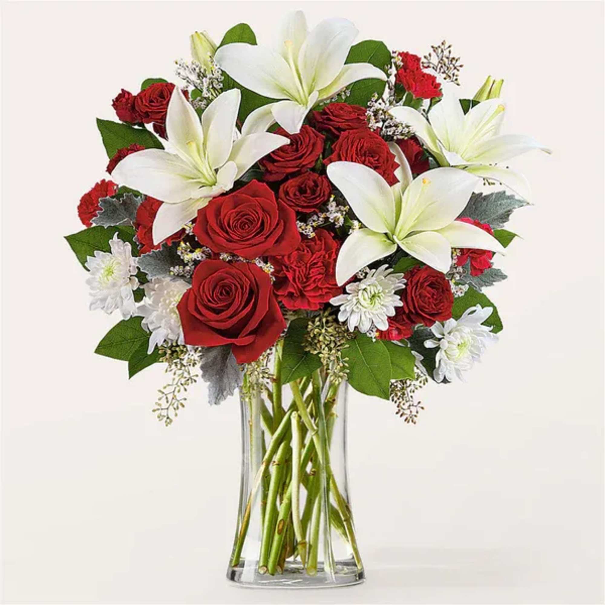 Red roses and white lilies arranged in a clear glass vase