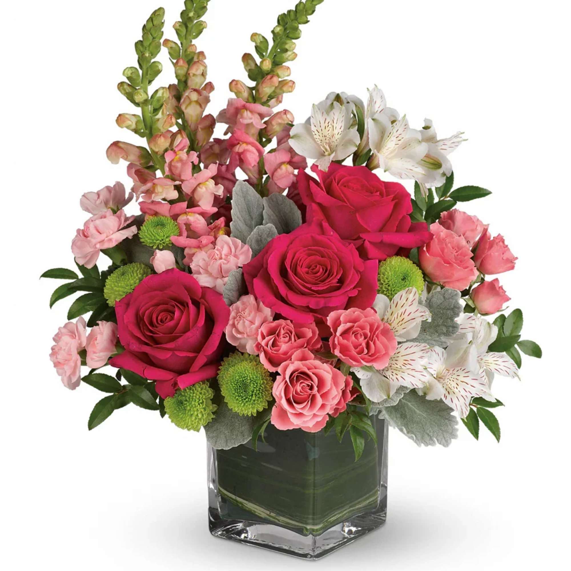 Pink roses and mixed blooms arranged in a clear square vase