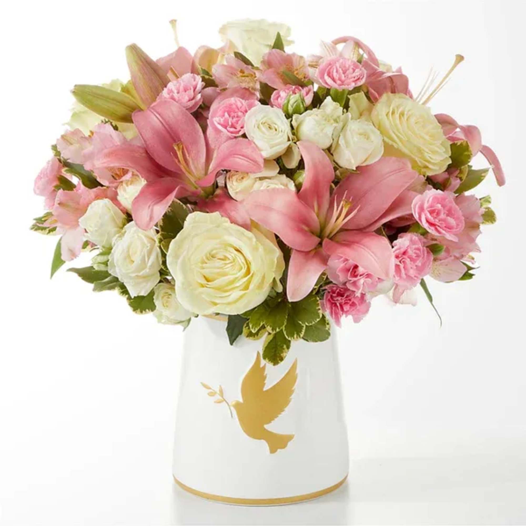 Pink and white flower arrangement in a white vase with a gold dove design