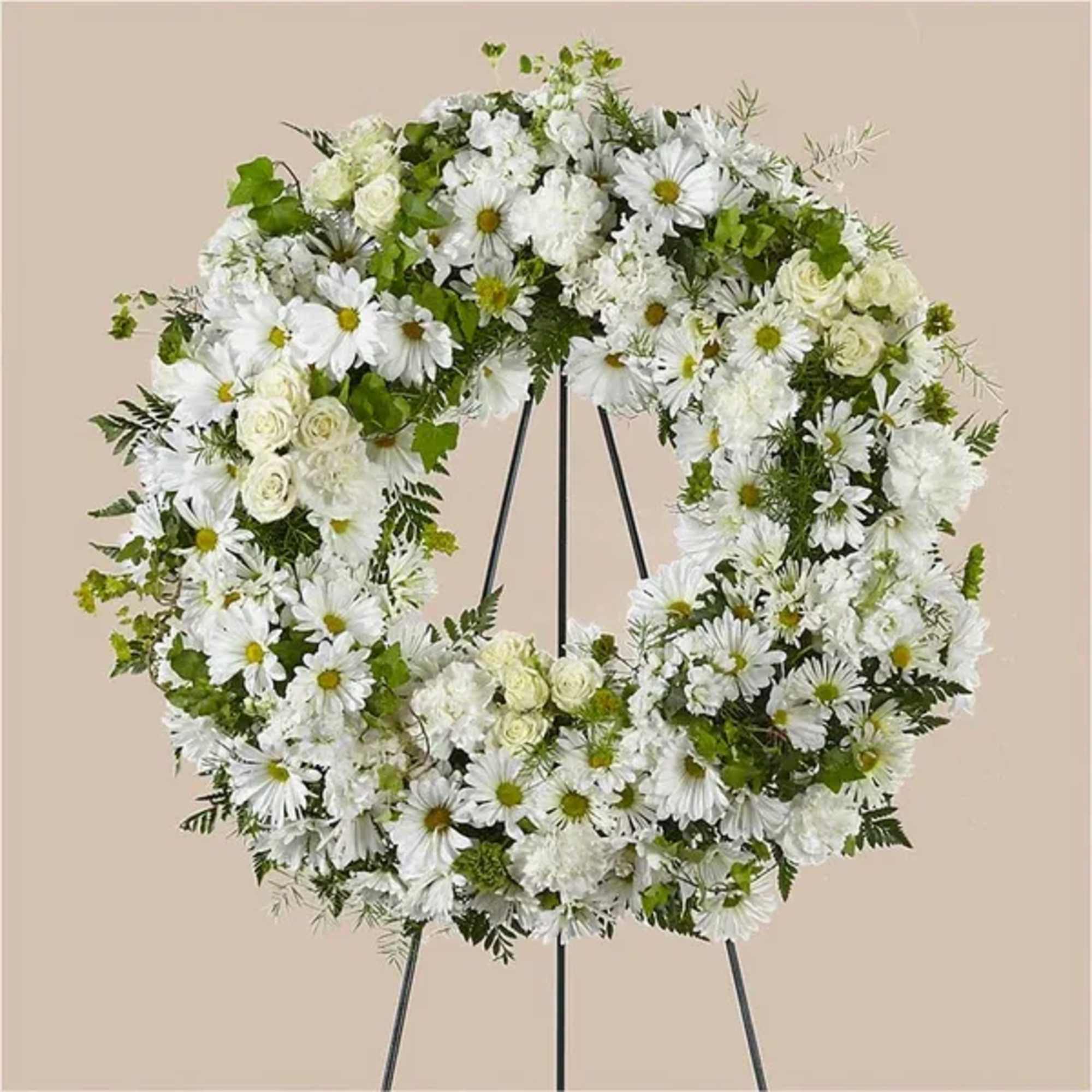 White floral wreath on a black stand