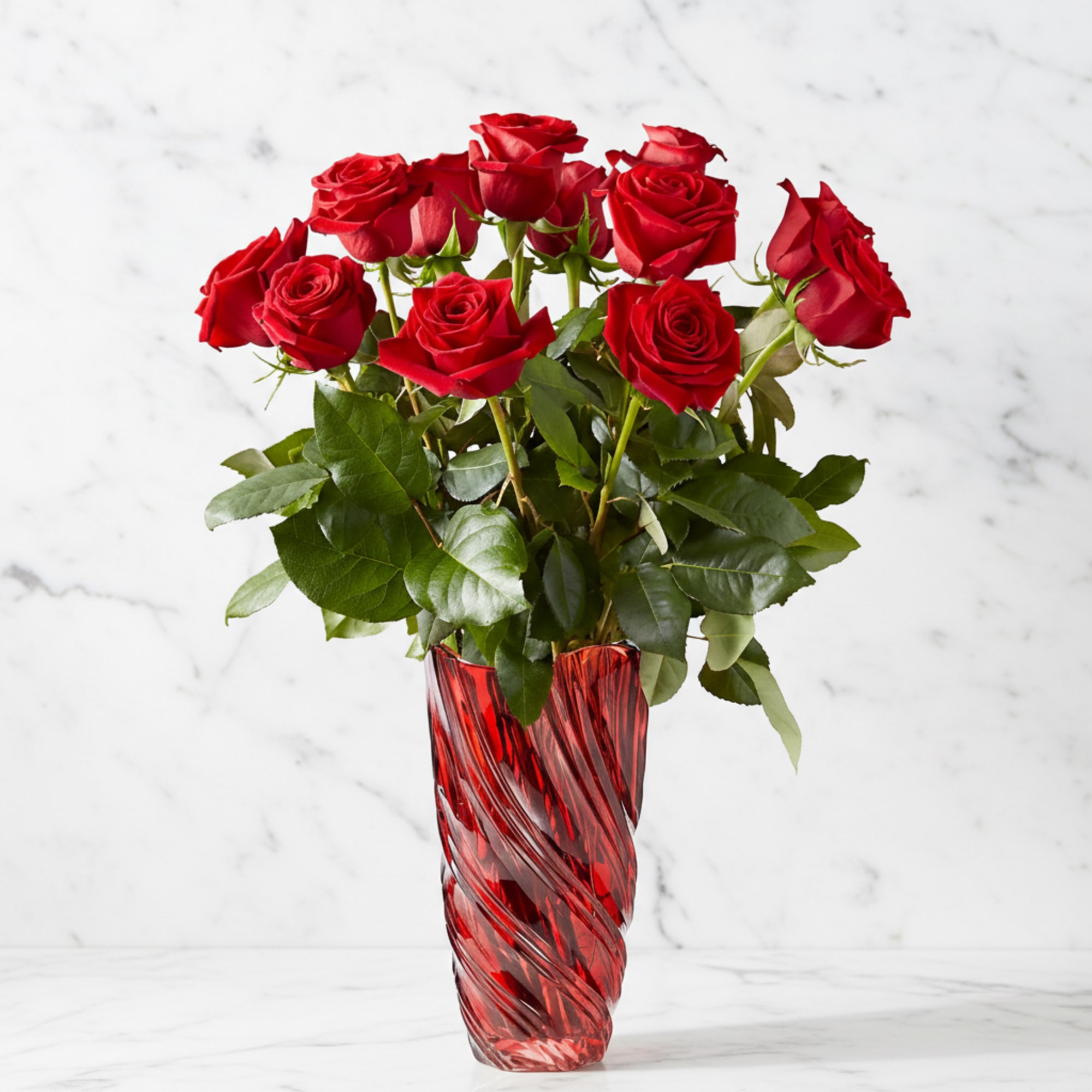 Red roses arranged in a tall red glass vase