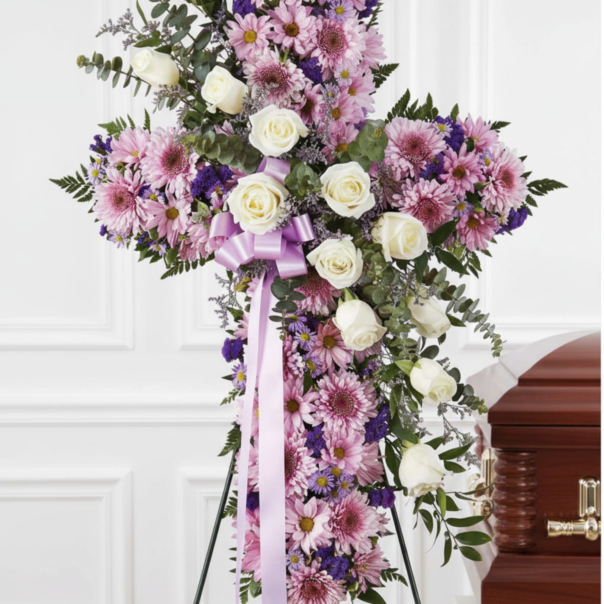 A large, dignified standing cross arrangement that immediately reads as a peaceful