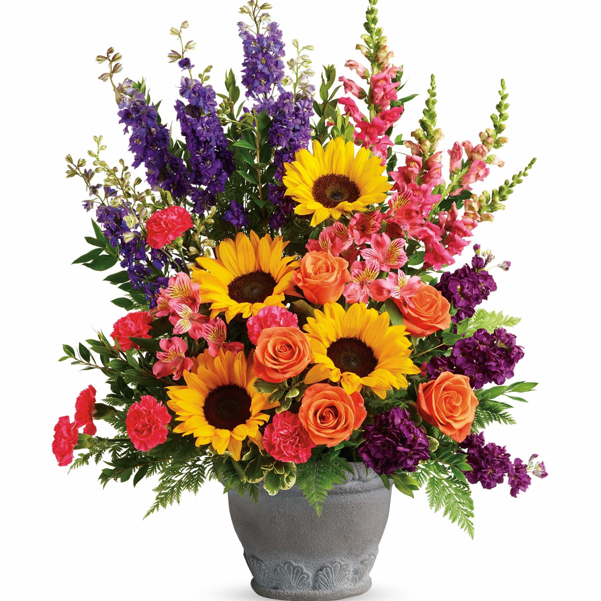 Colorful mixed bouquet in a gray vase with sunflowers, roses, and purple spikes
