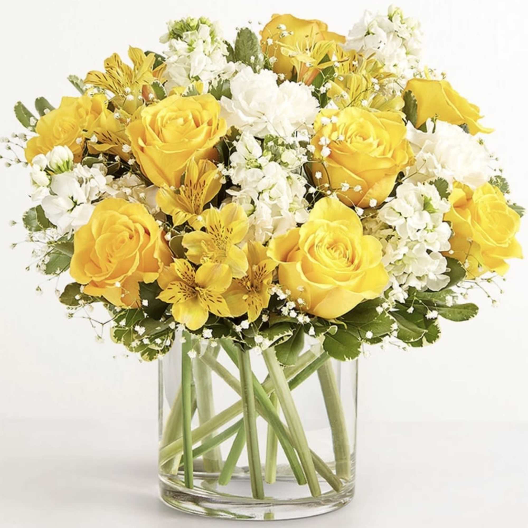 Yellow and white rose bouquet in a clear glass vase