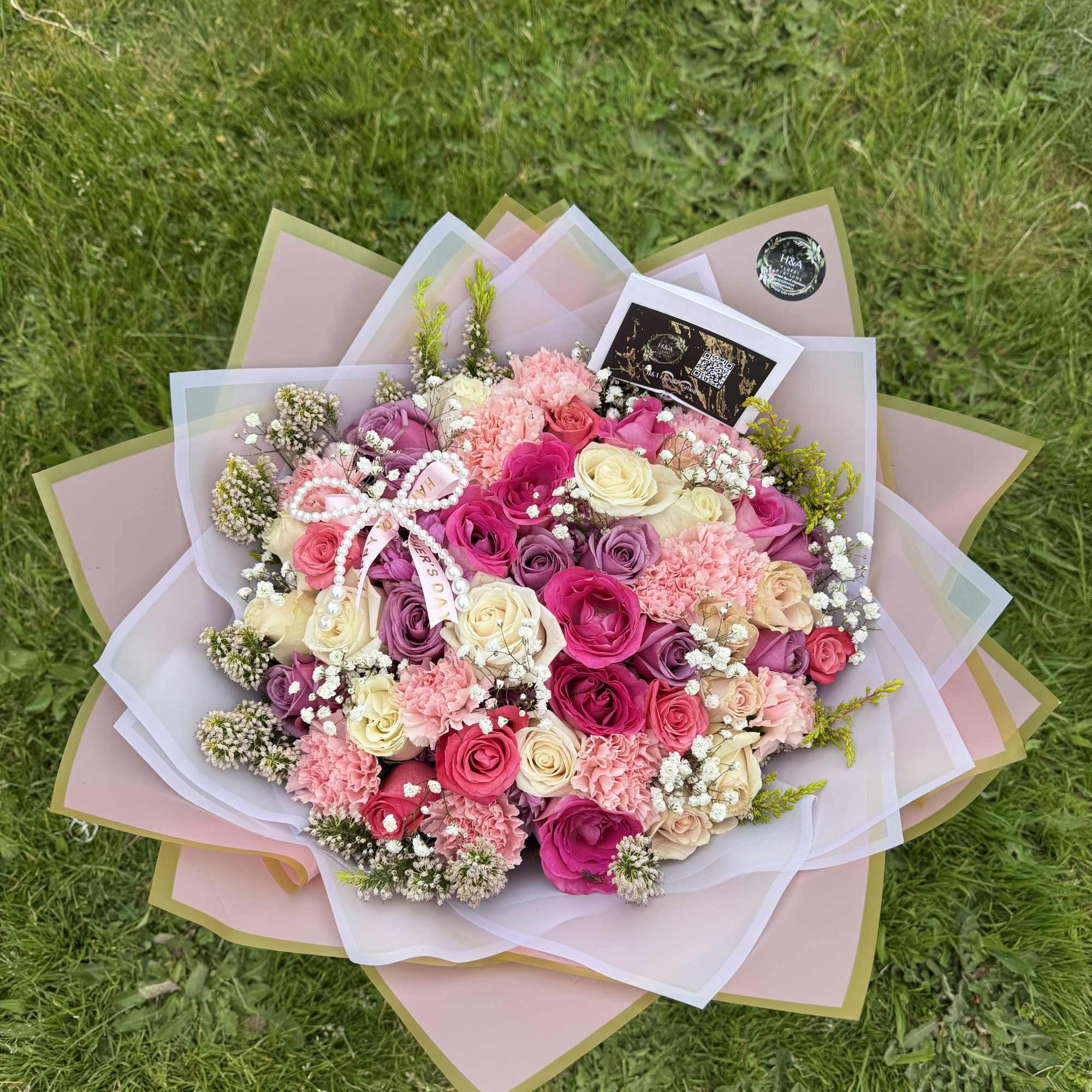 Large bouquet of pink, cream, and purple roses with carnations