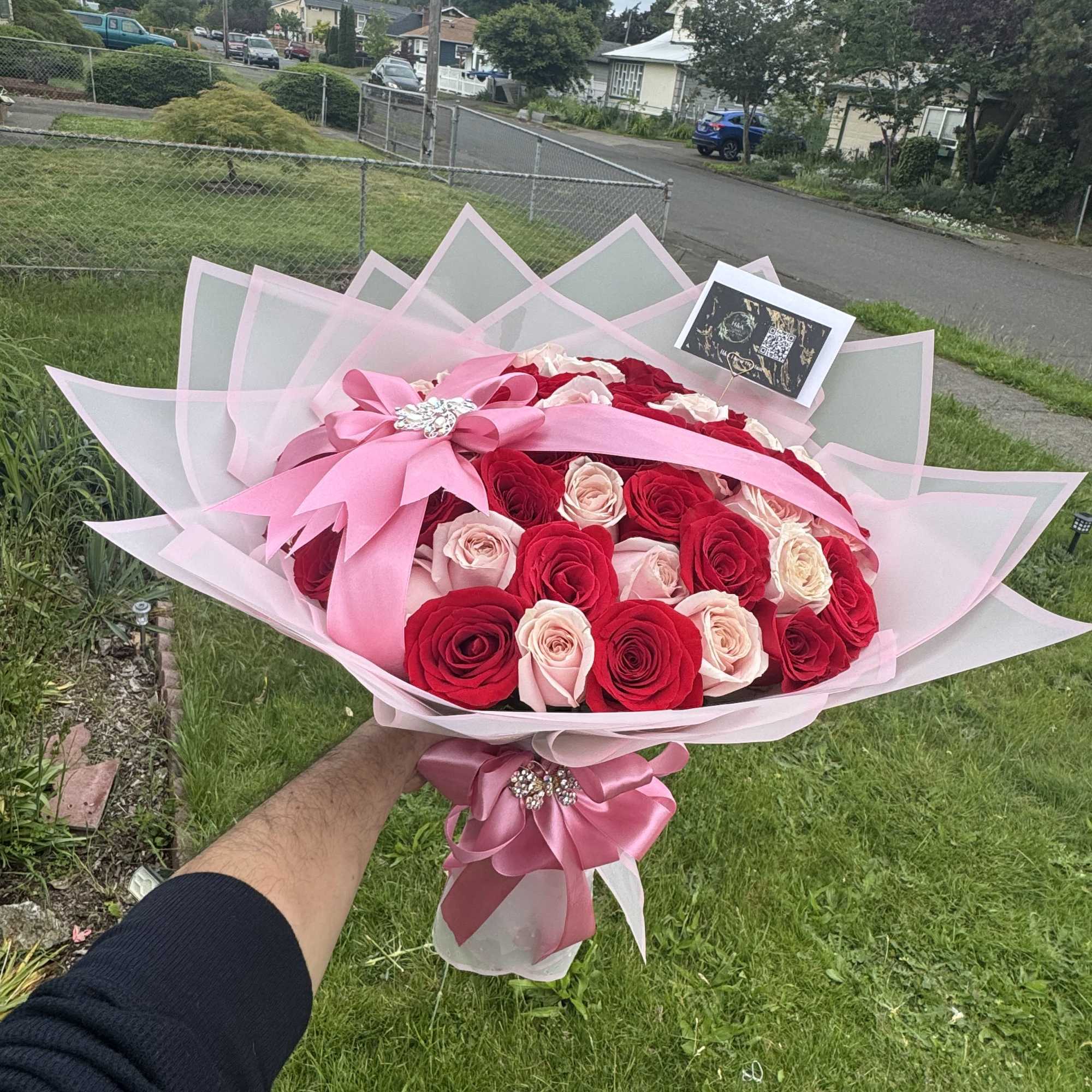 Large bouquet of red and blush roses wrapped in pink paper