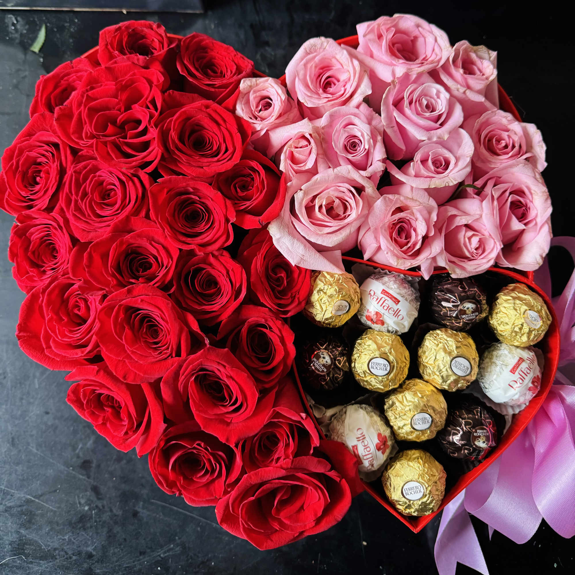 Heart-shaped box of red and pink roses with assorted chocolates