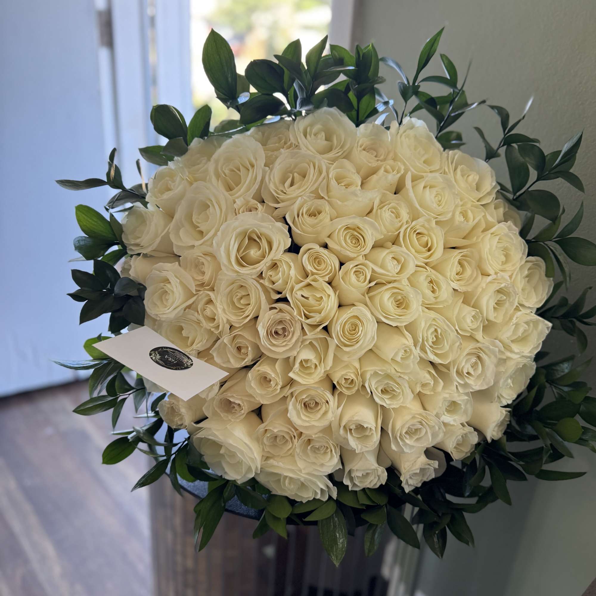Large bouquet of cream roses with dark green foliage