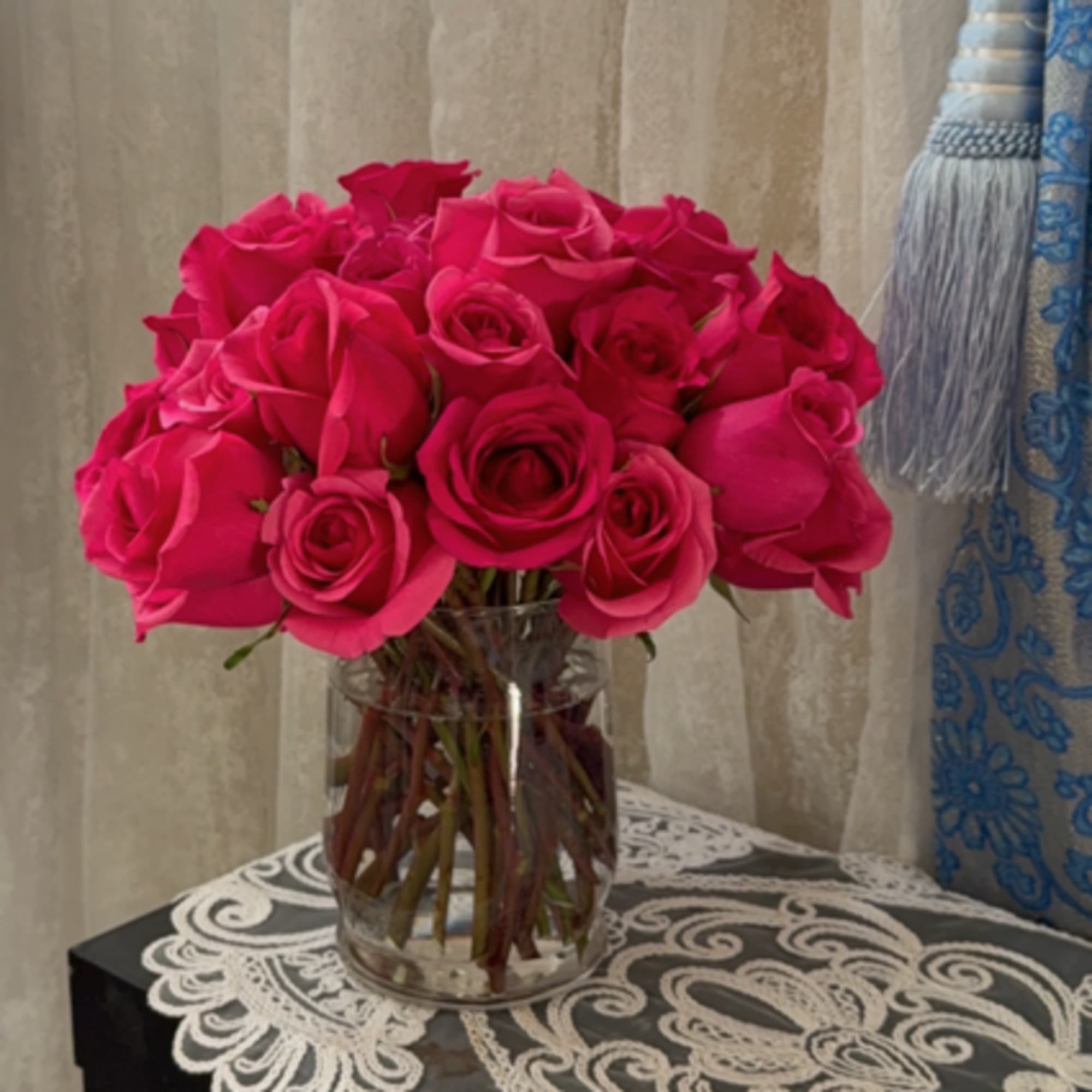 Hot pink roses arranged in a clear glass vase