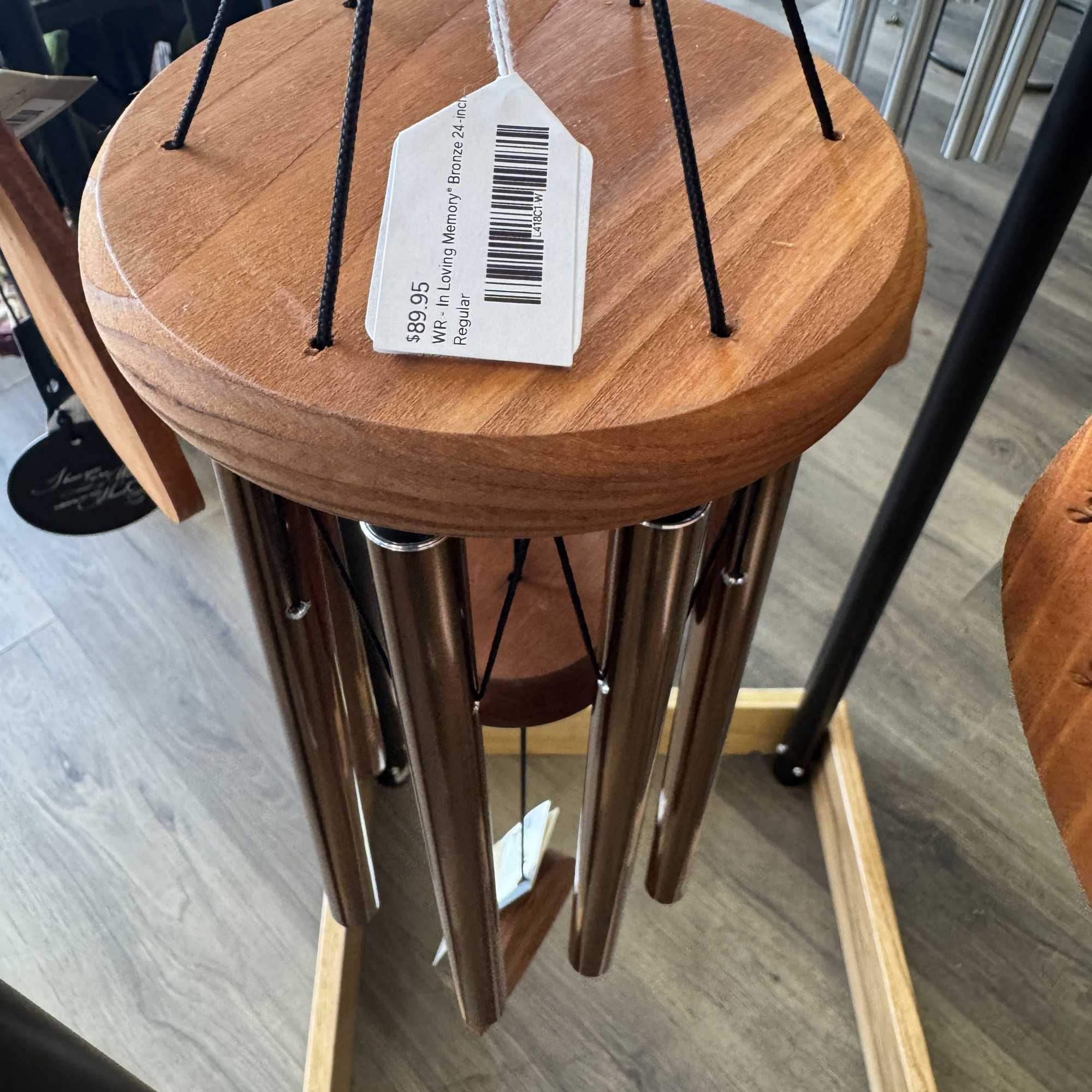 Wooden wind chime with metal tubes and a hanging price tag