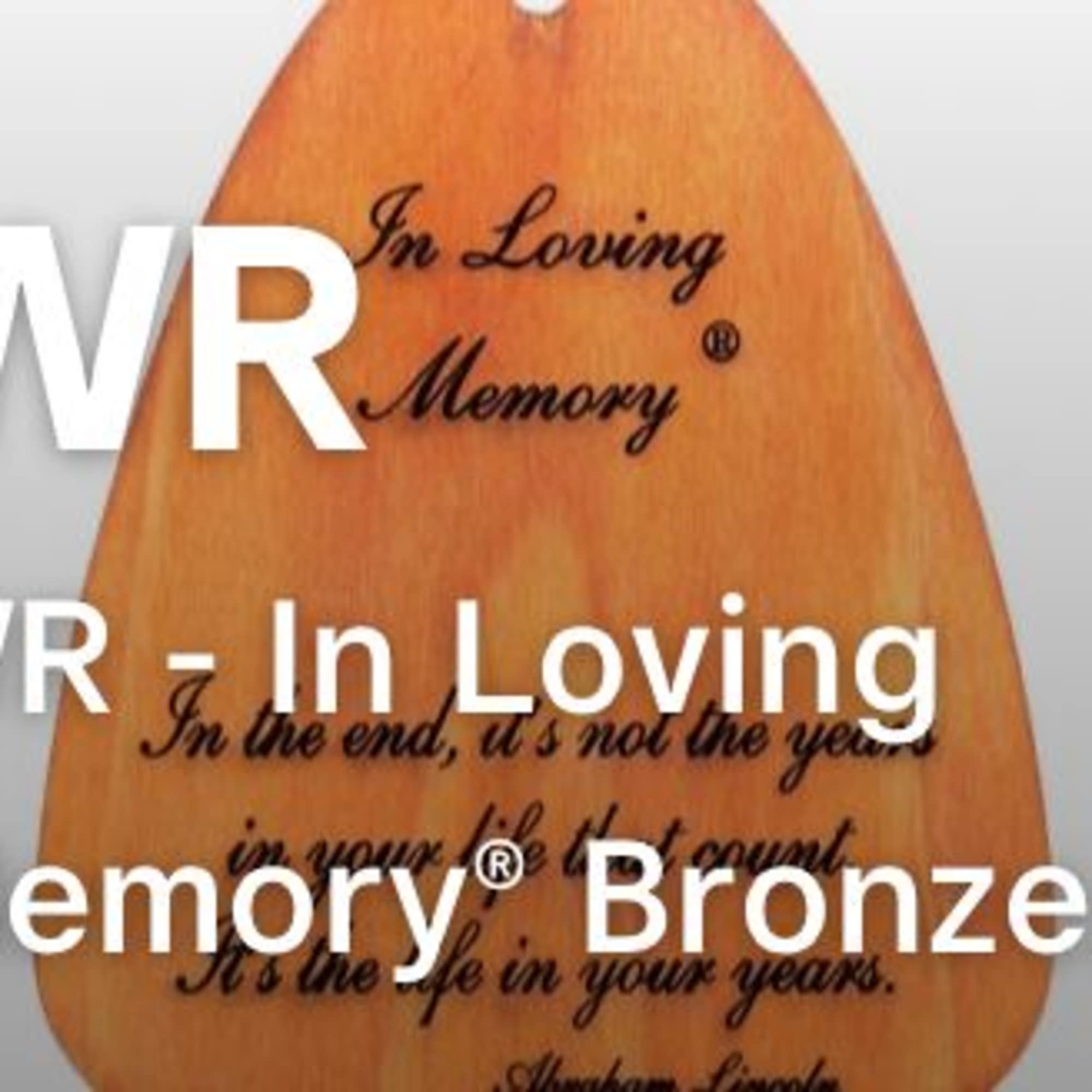 Wooden memorial plaque with engraved text on a gray background
