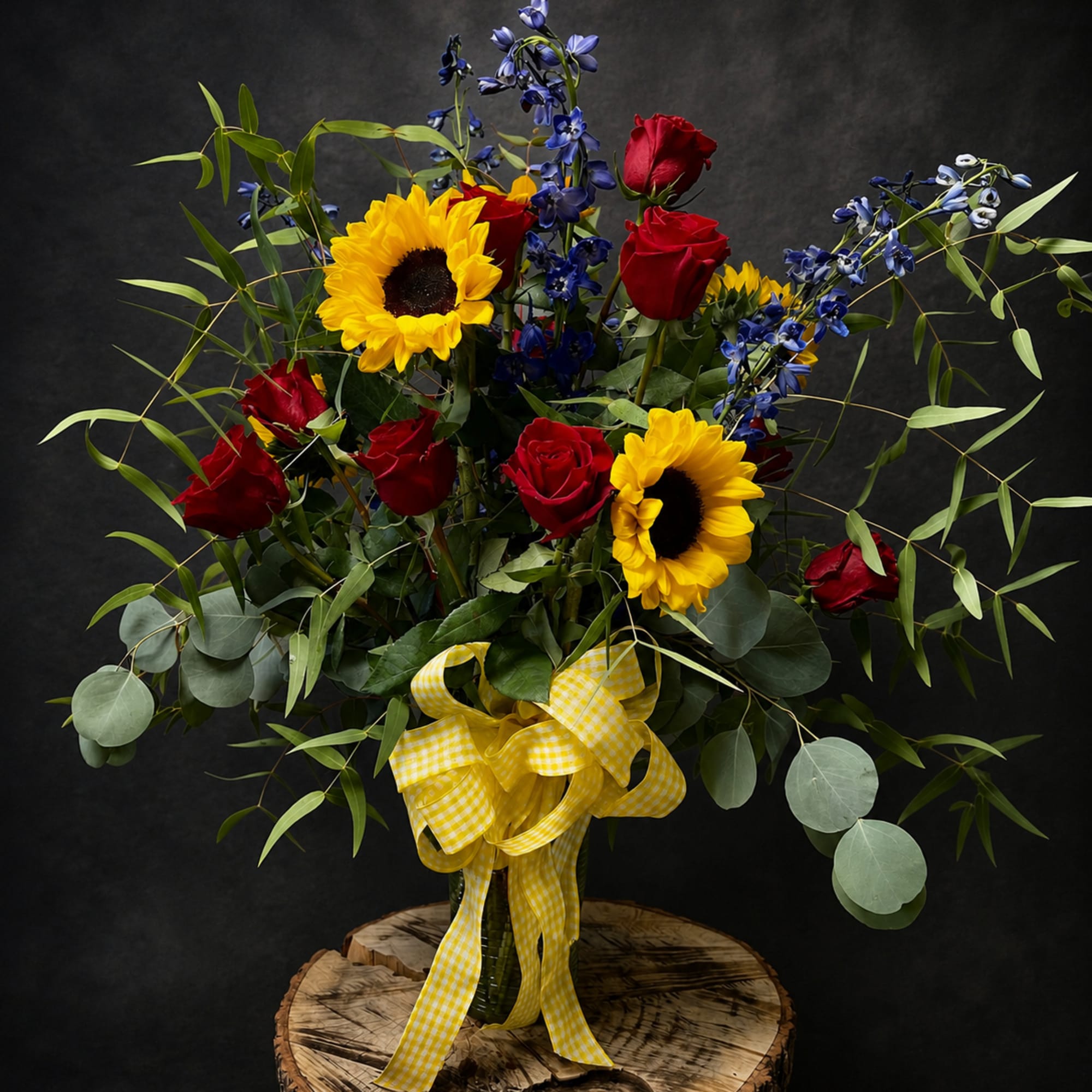 Sunflowers and red roses collide in a bold, high-contrast bouquet that feels