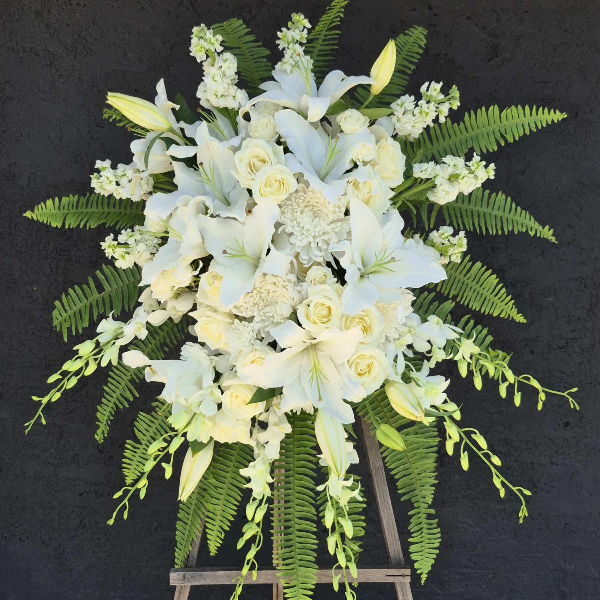 White floral standing spray on a wooden easel