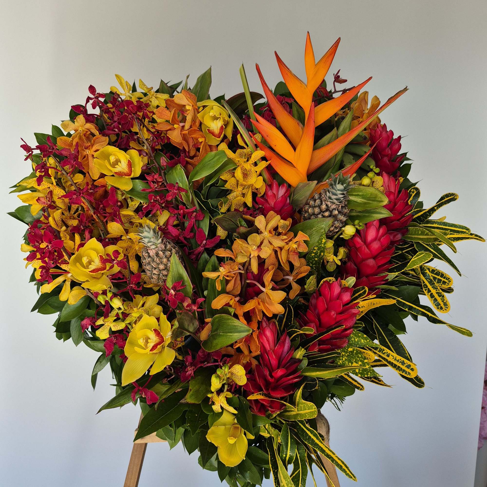Tropical floral spray with orchids, bird of paradise, and pineapples