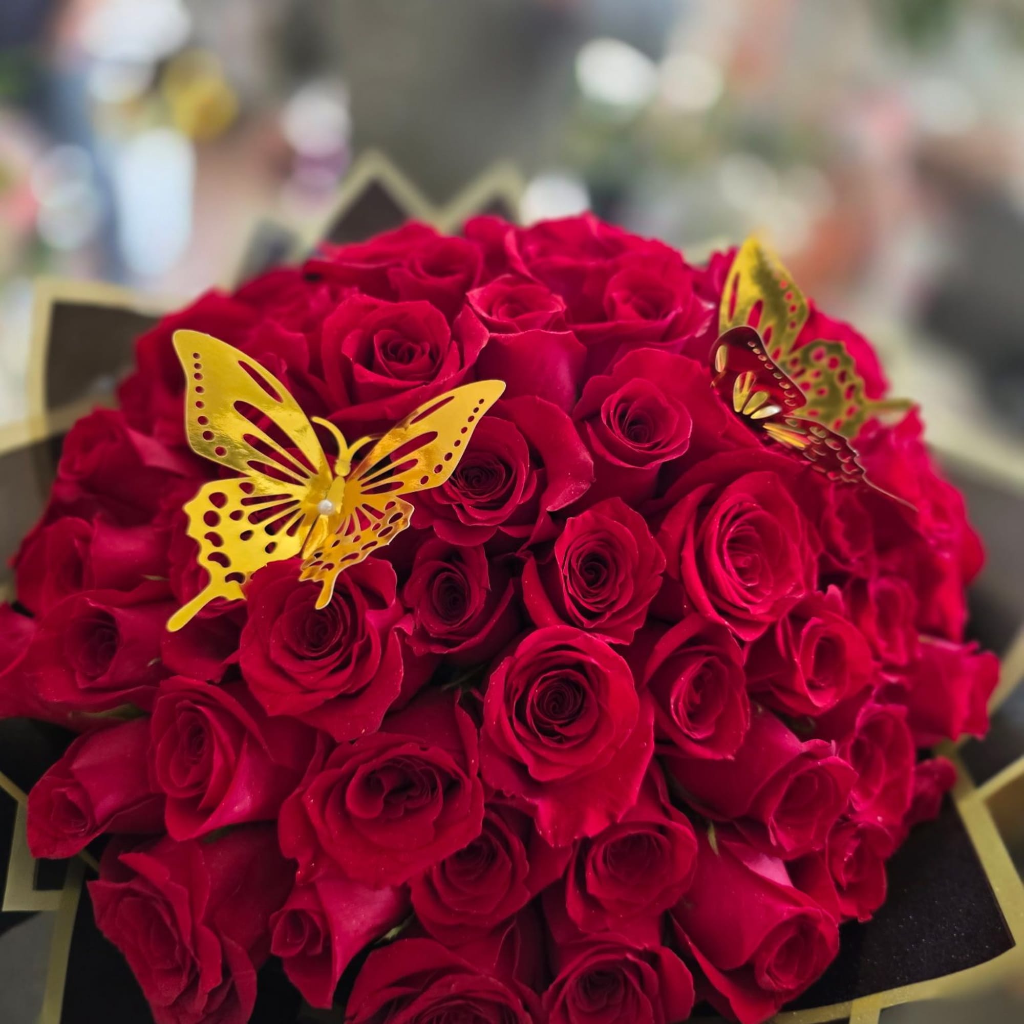 Bouquet of red roses with gold butterfly decorations