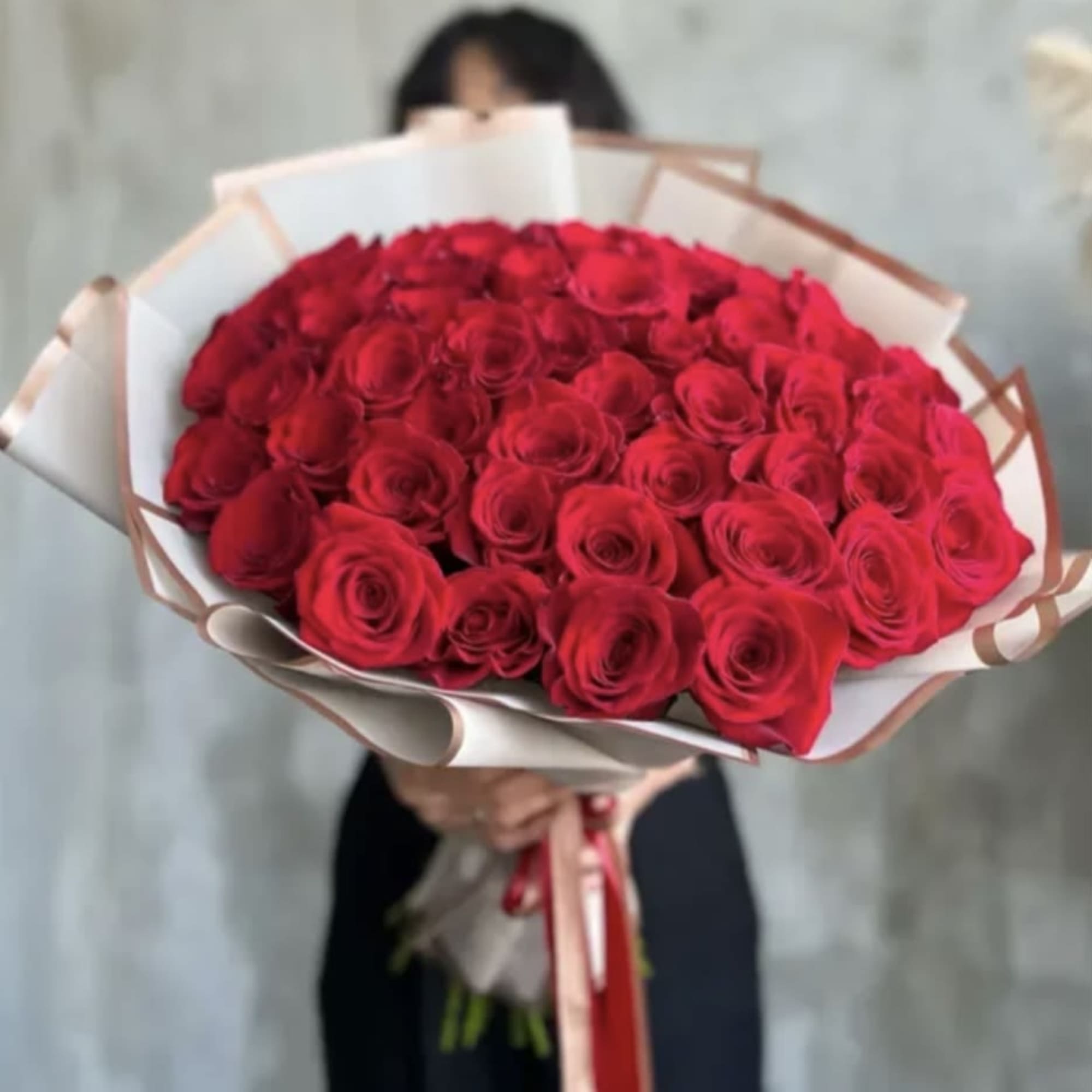 Large bouquet of red roses wrapped in white paper