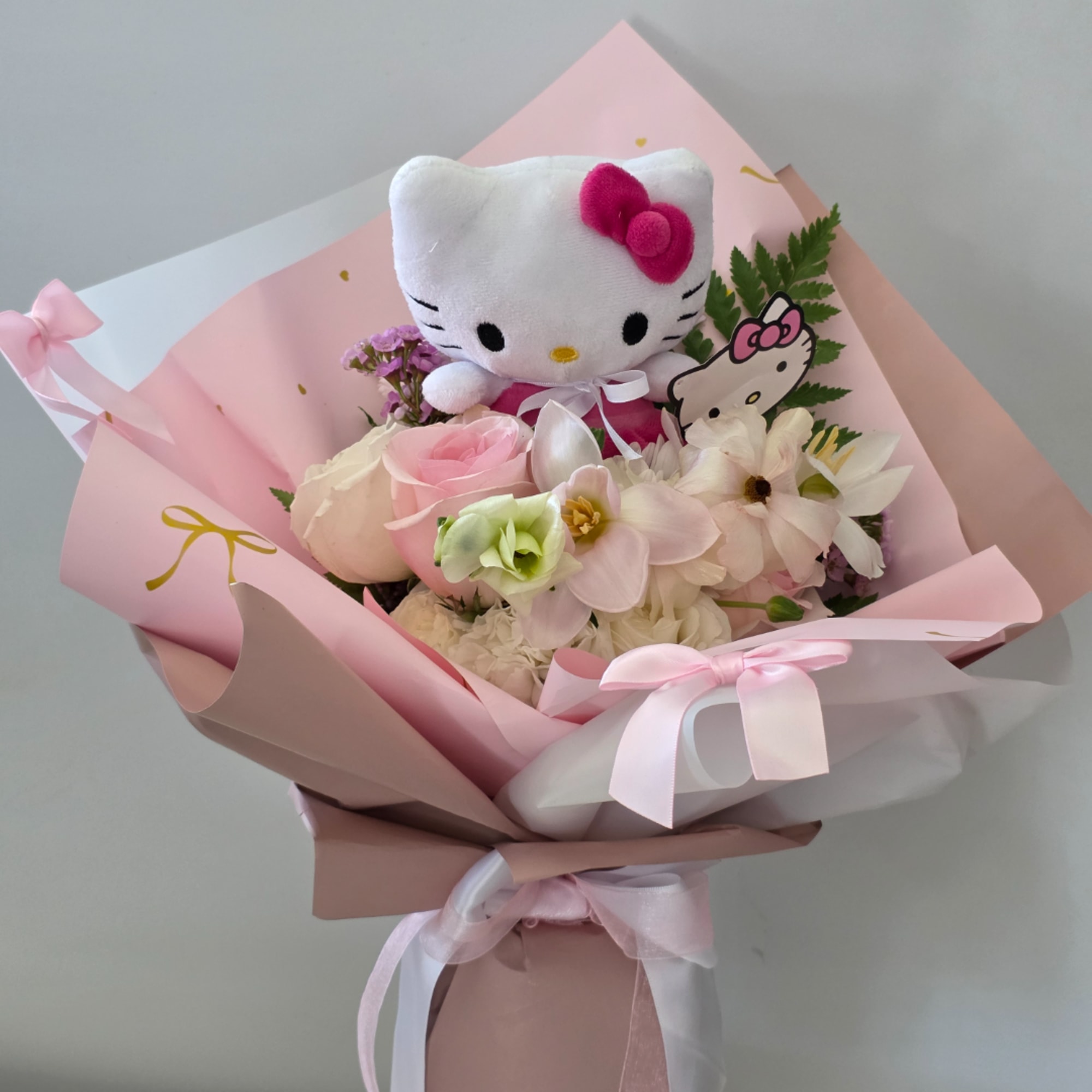 Pink bouquet with a Hello Kitty plush and pastel flowers wrapped in pink paper