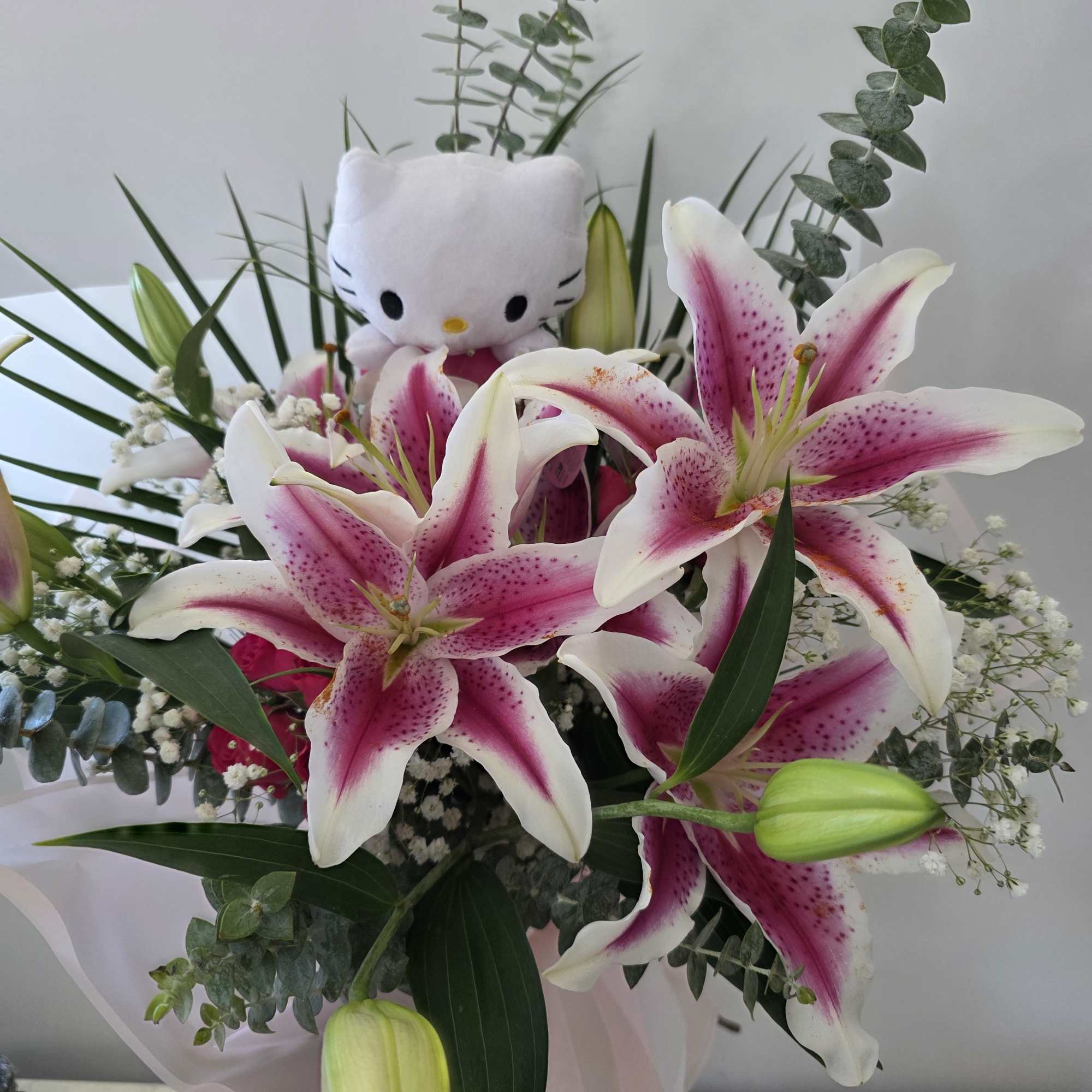 Bouquet of pink-and-white lilies with a small Hello Kitty plush