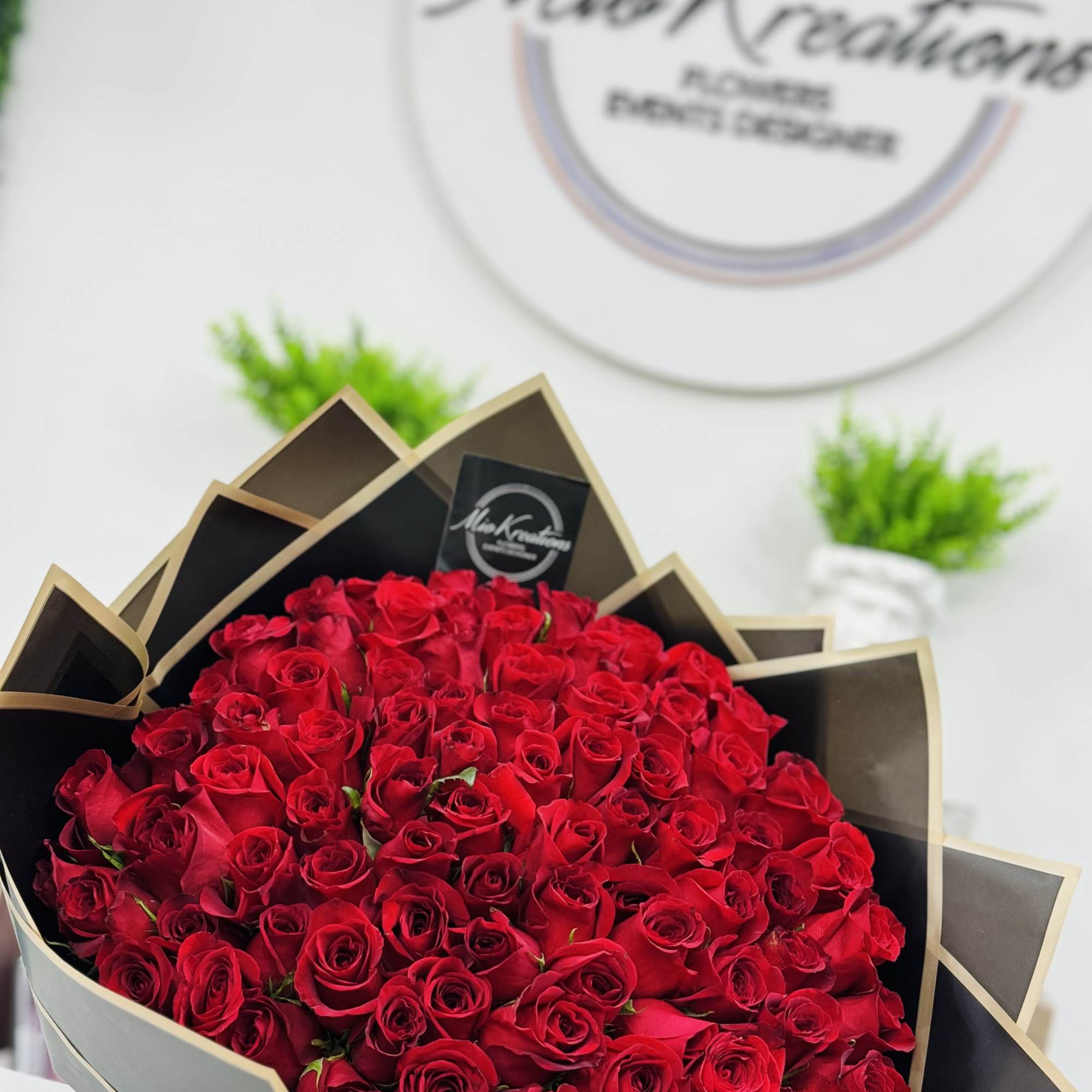Large bouquet of red roses wrapped in black and gold paper