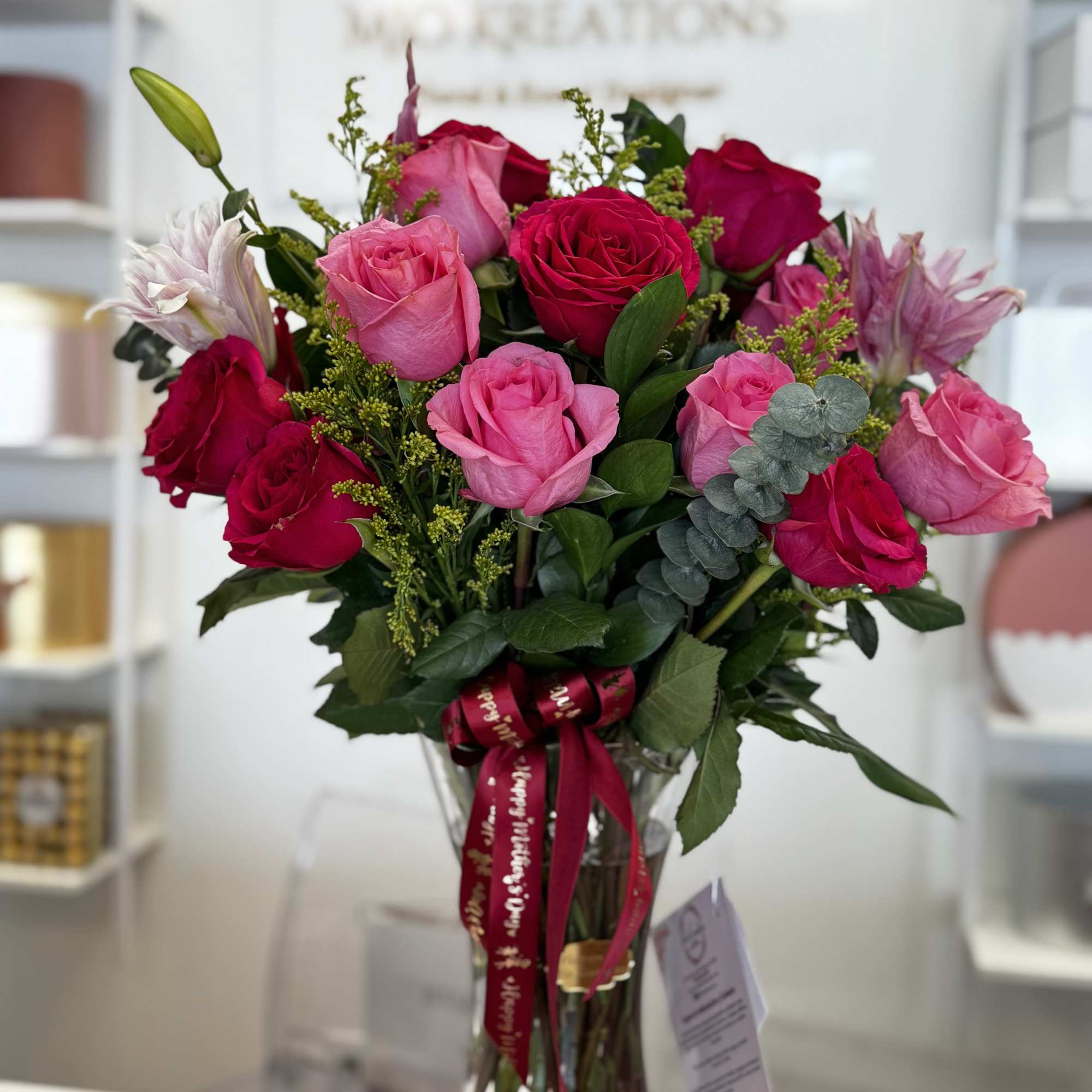 Pink and red roses arranged in a clear glass vase