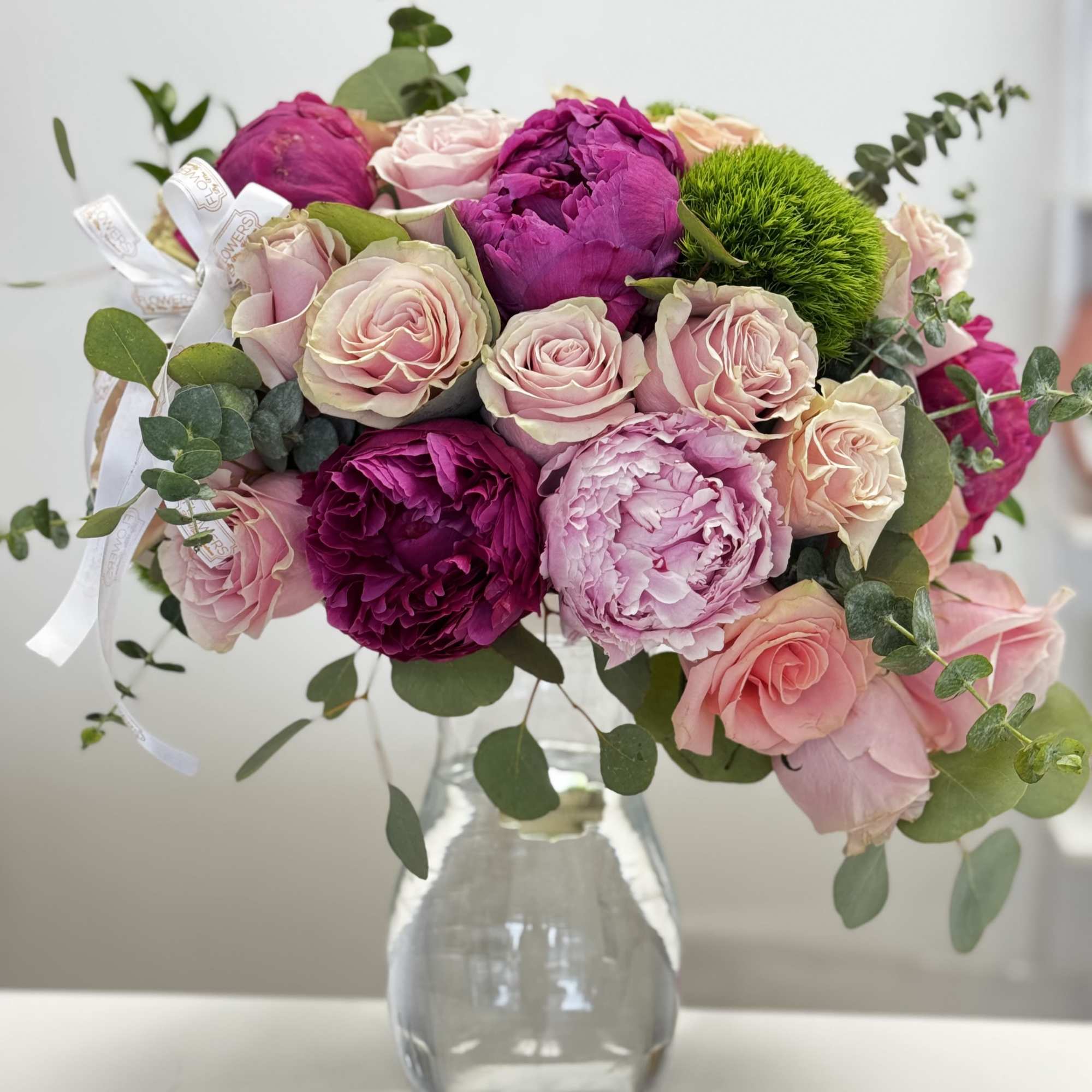 Pink and magenta rose bouquet in a clear glass vase