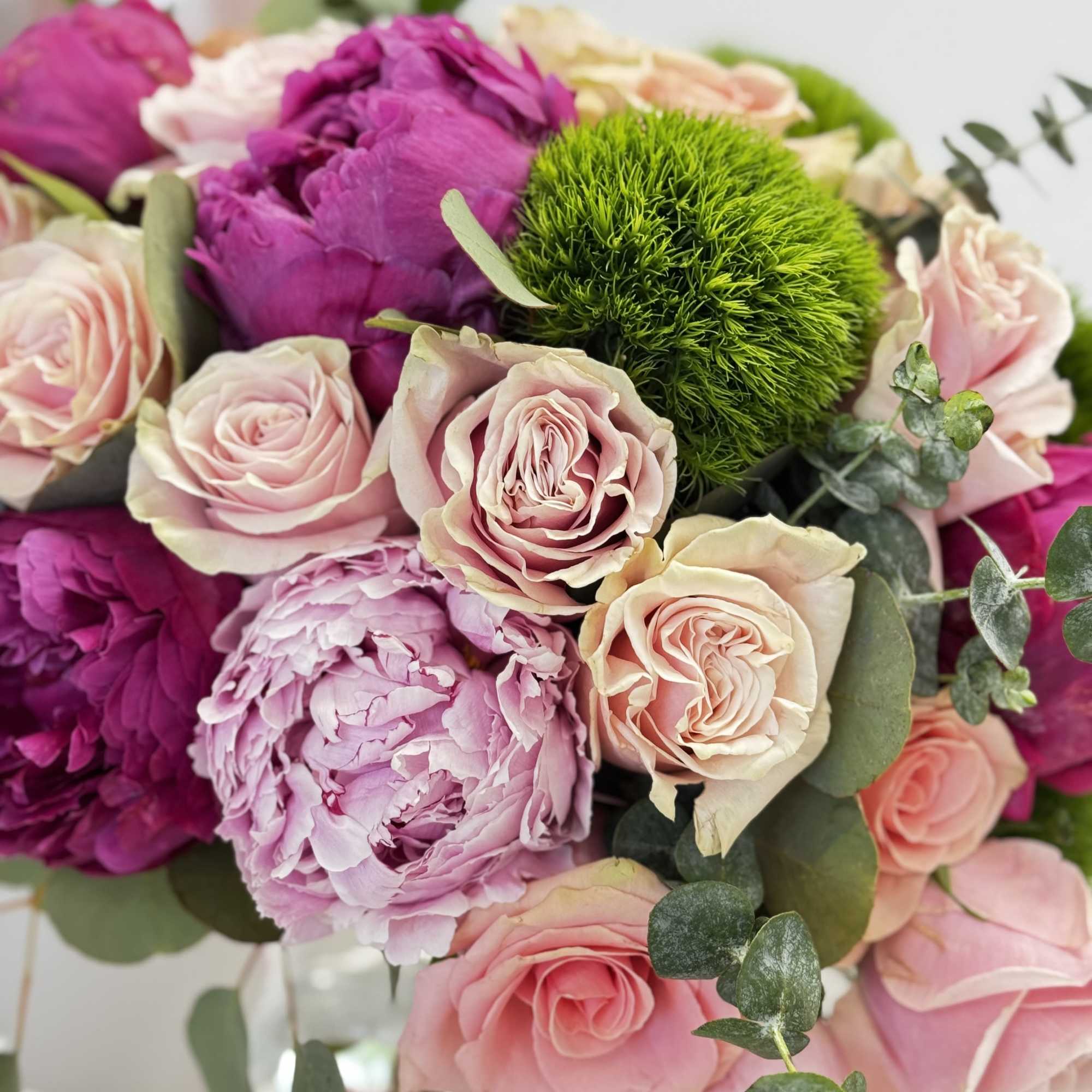 Bouquet of pink and purple roses with a green pom-pom bloom