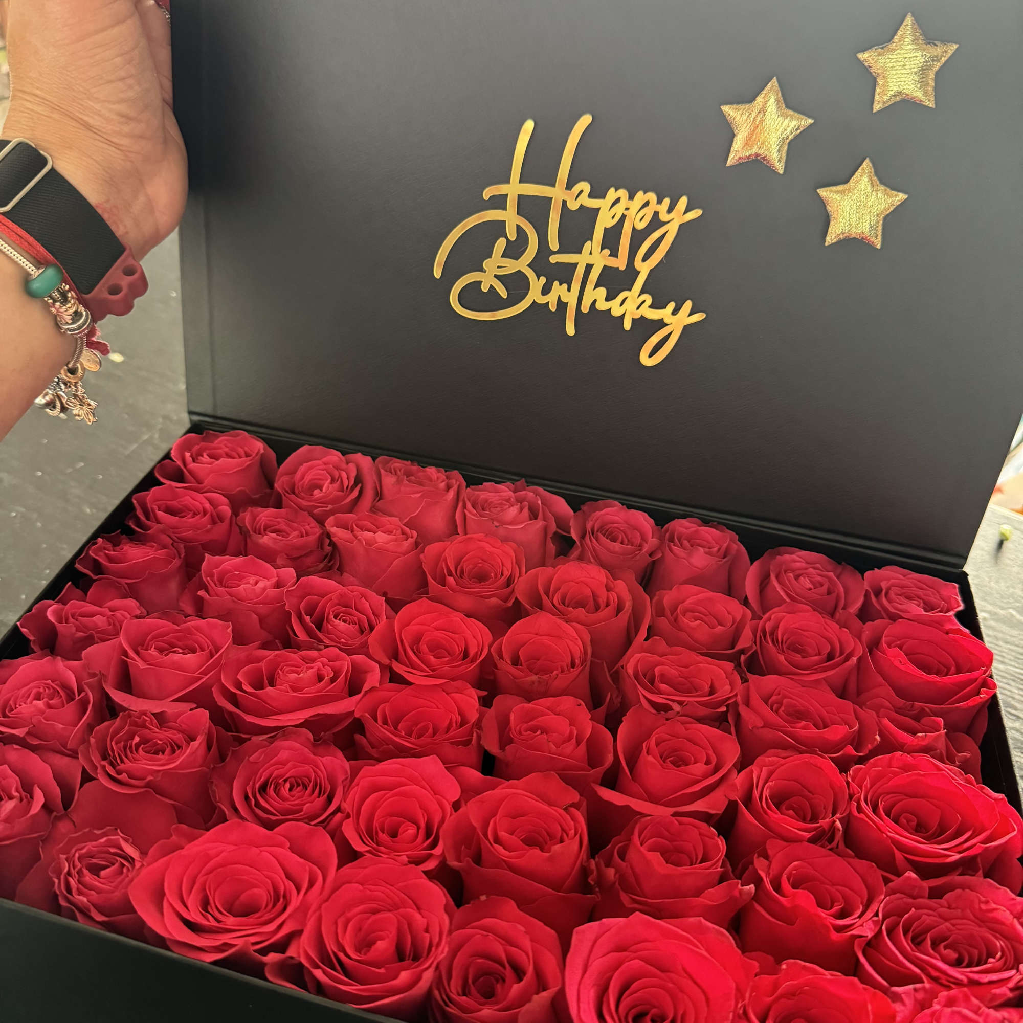 Box of red roses with a gold Happy Birthday message