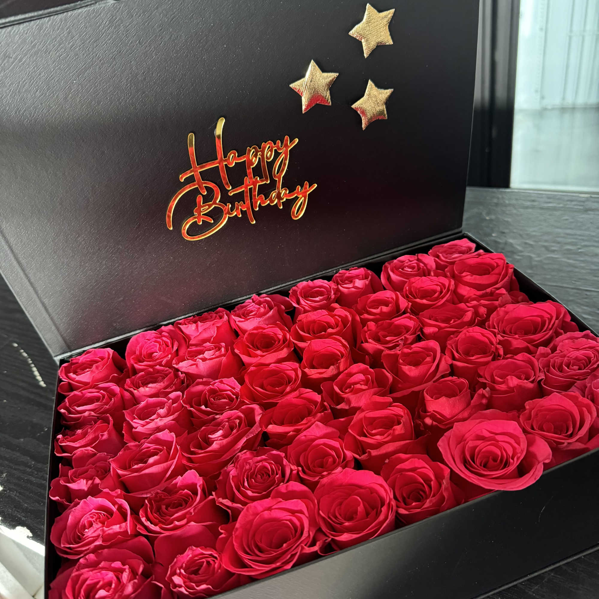 Box of bright pink roses with a Happy Birthday message