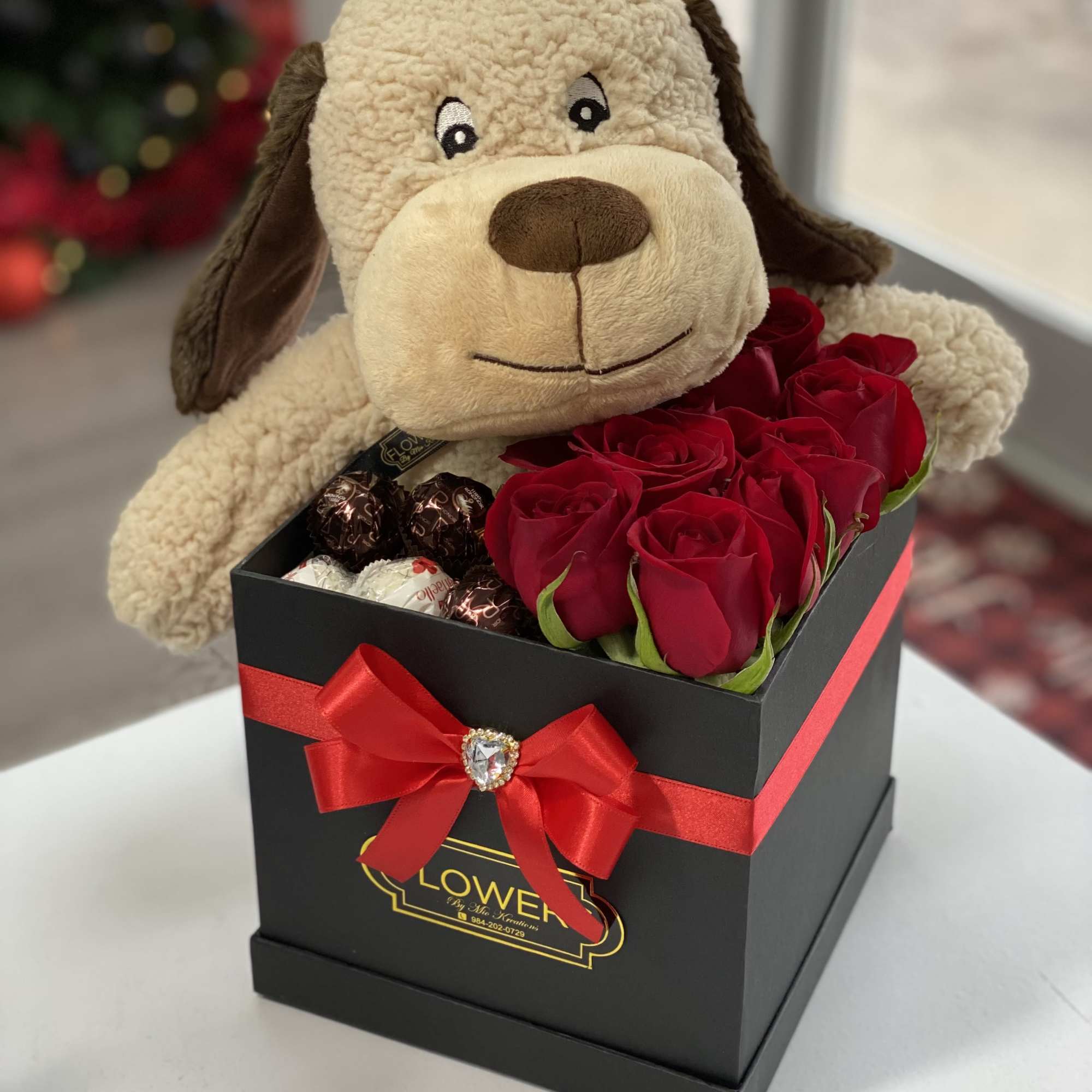 Plush dog in a black gift box with red roses and chocolates