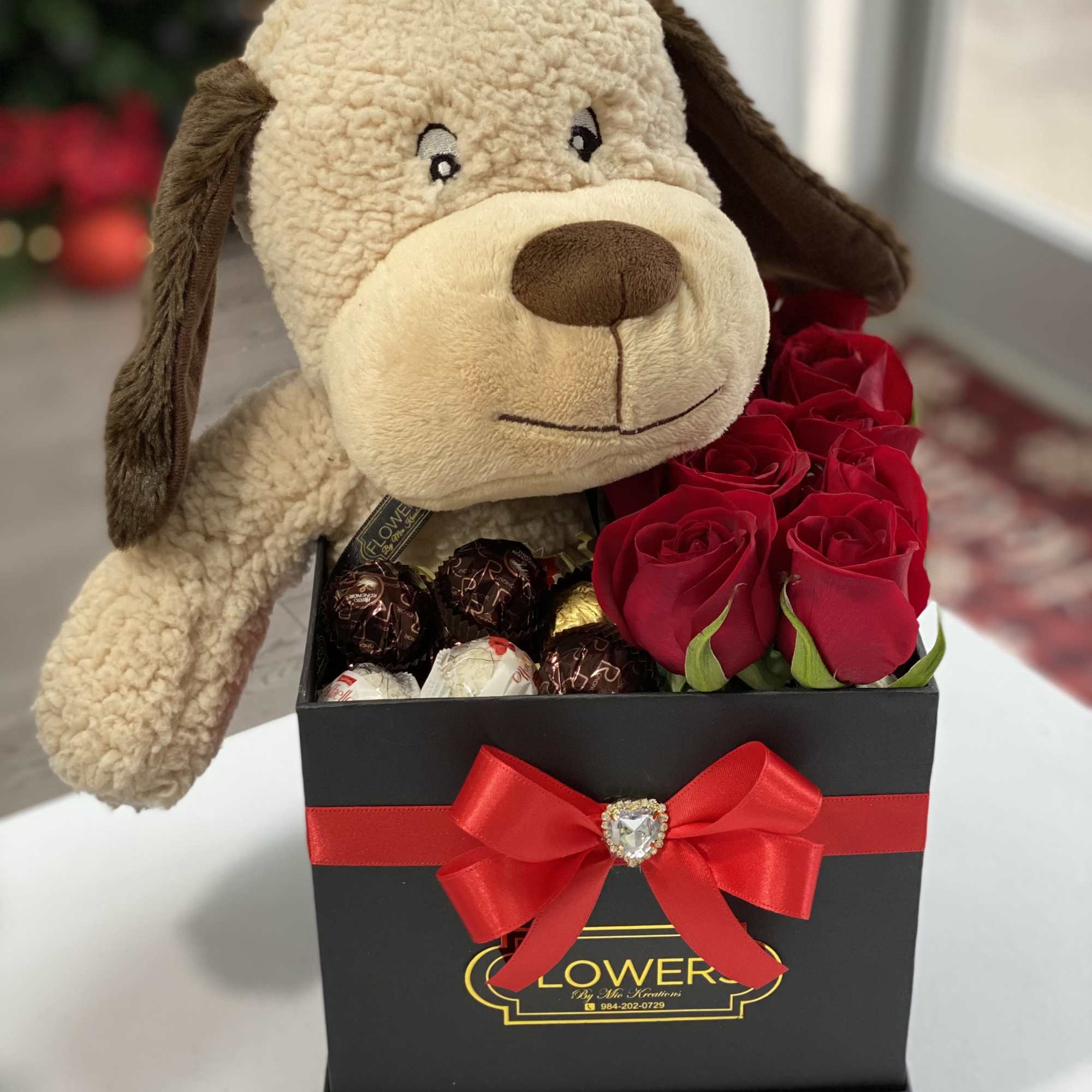 Plush dog in a gift box with red roses and chocolates