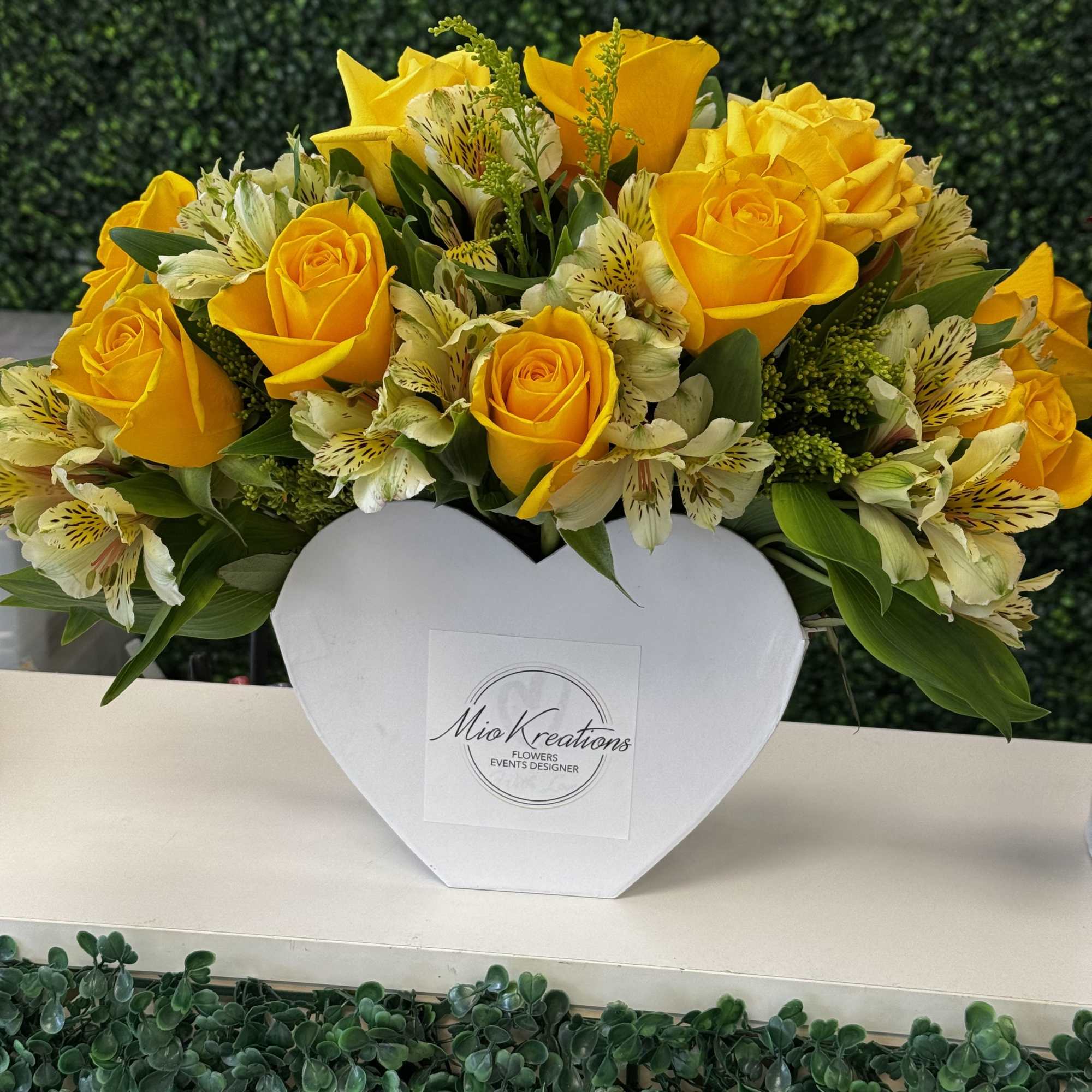Yellow roses and white alstroemeria in a white heart-shaped box