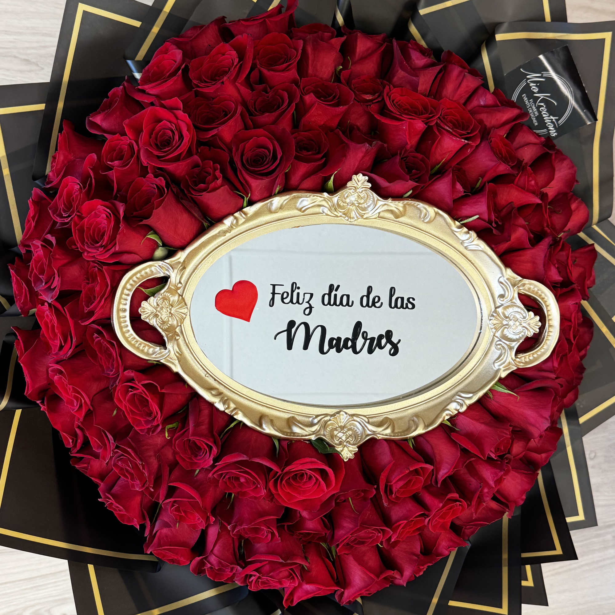 Round bouquet of red roses with a gold-framed Mother's Day sign