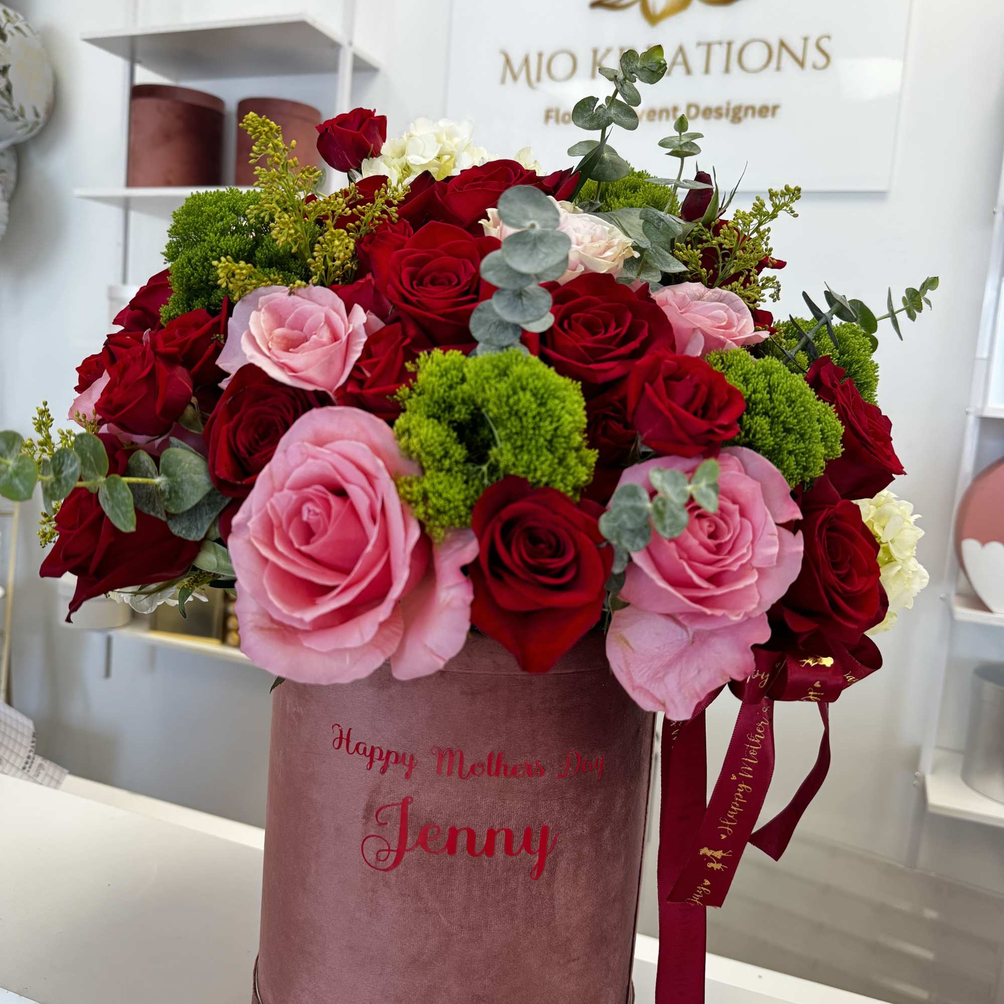 Bouquet of red and pink roses in a pink hatbox