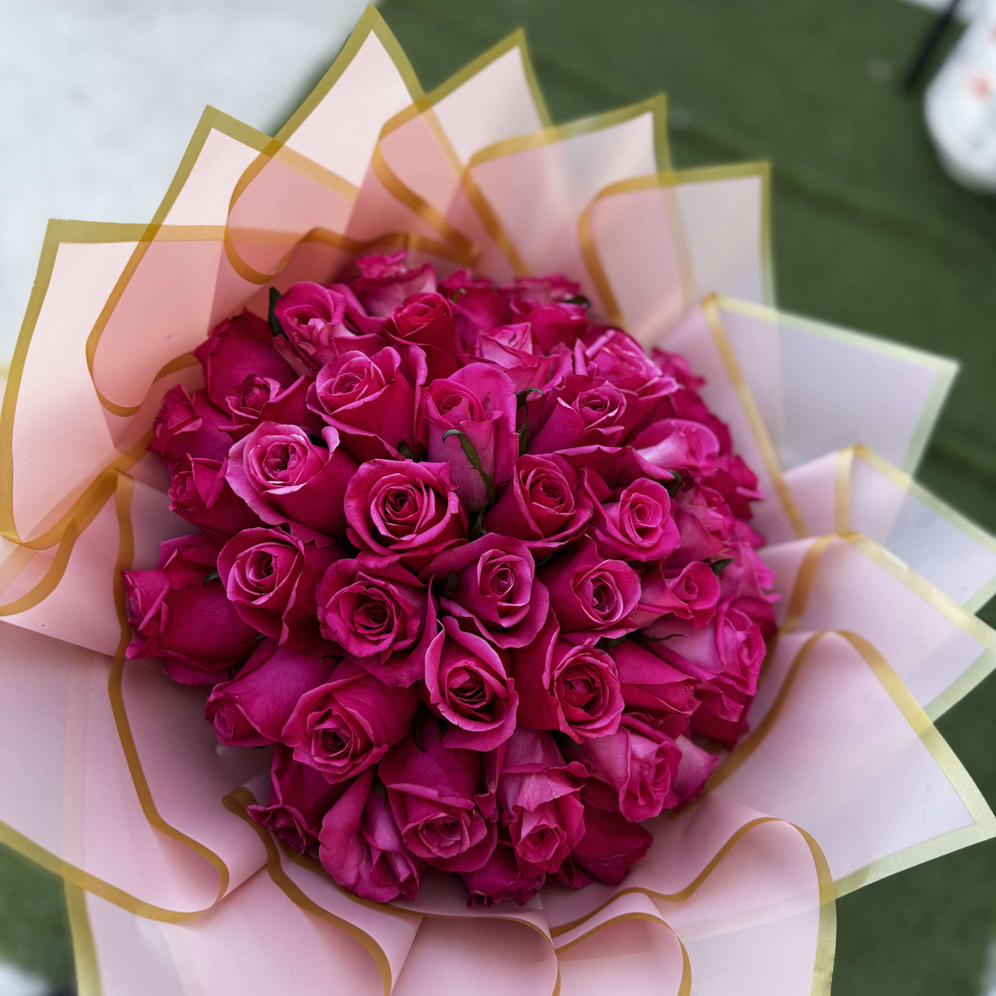 Bouquet of bright pink roses wrapped in pale pink paper