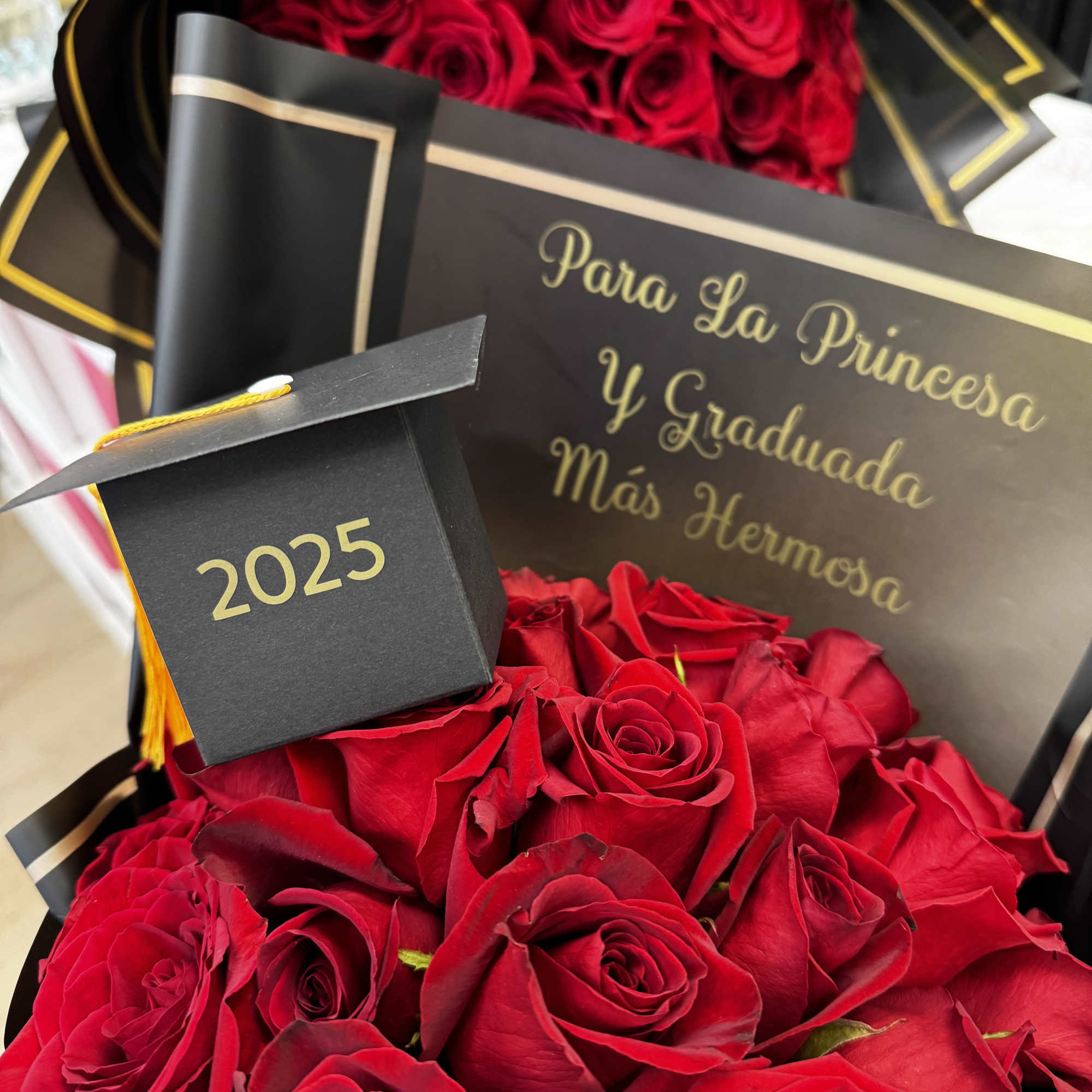 Red roses in black and gold graduation packaging with a 2025 cap