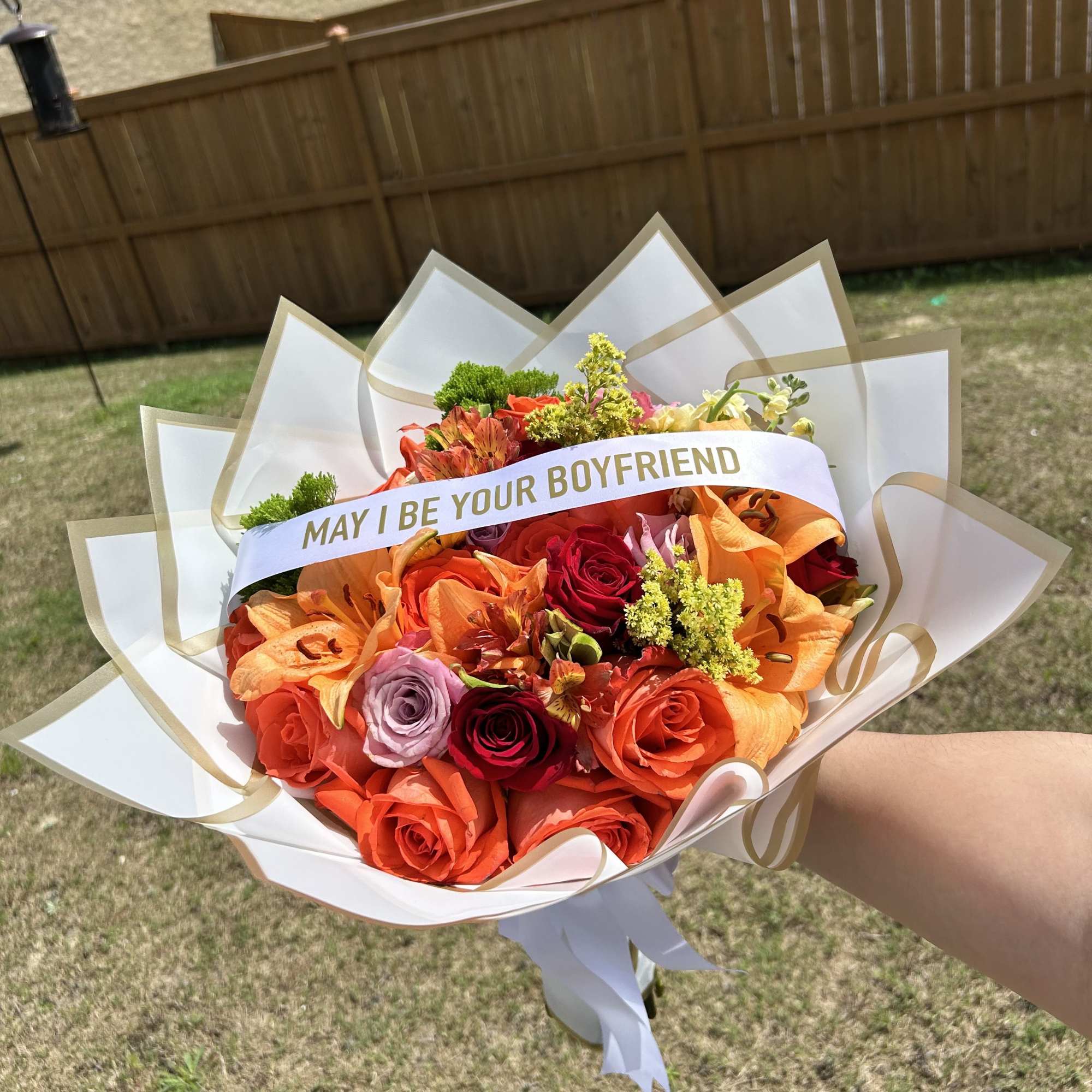 Bouquet of orange and red roses with a "MAY I BE YOUR BOYFRIEND" sash