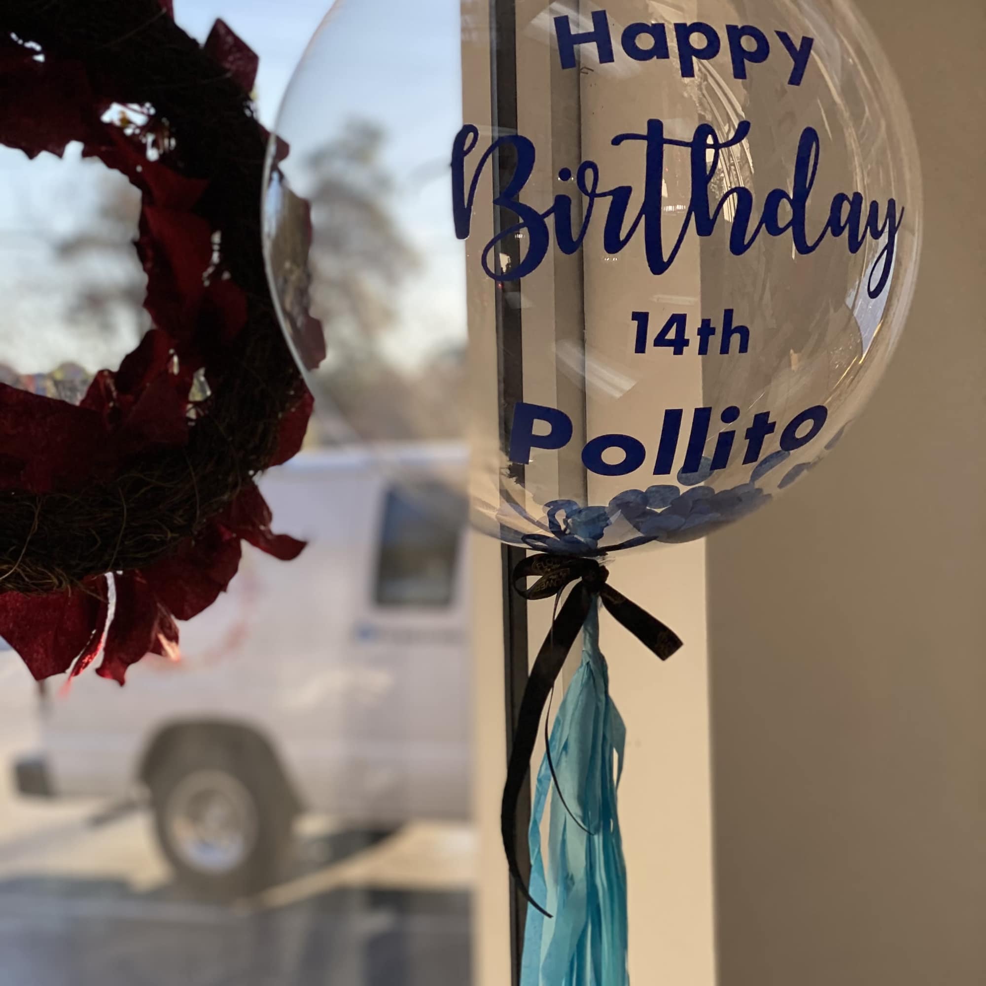 Clear birthday balloon with blue text and ribbon tassels