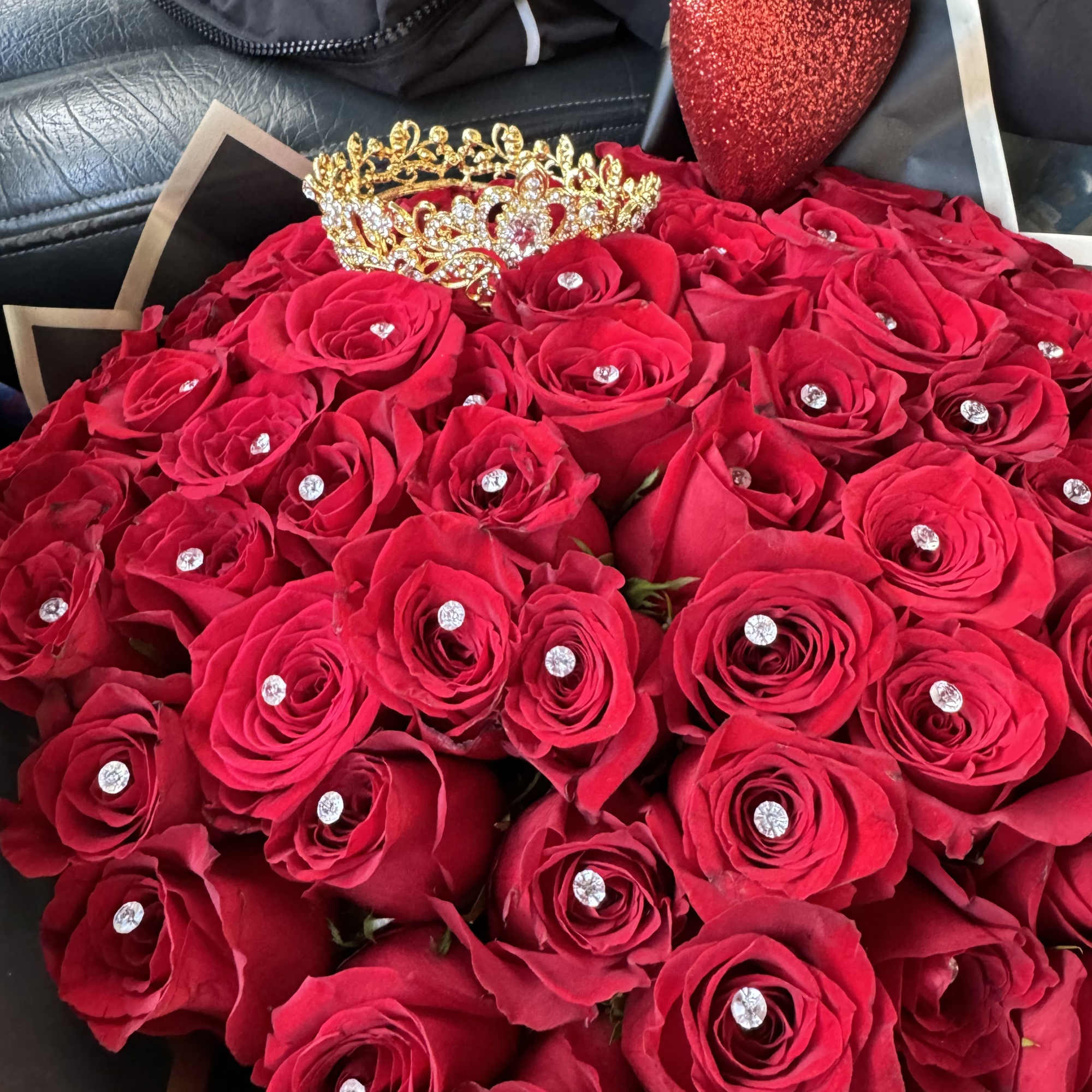 Bouquet of red roses with a gold crown and glittery heart topper