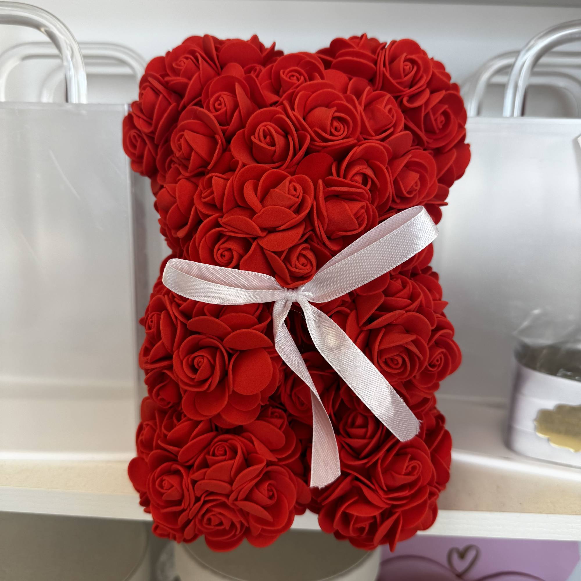 Red rose-shaped arrangement tied with a white ribbon in a white box