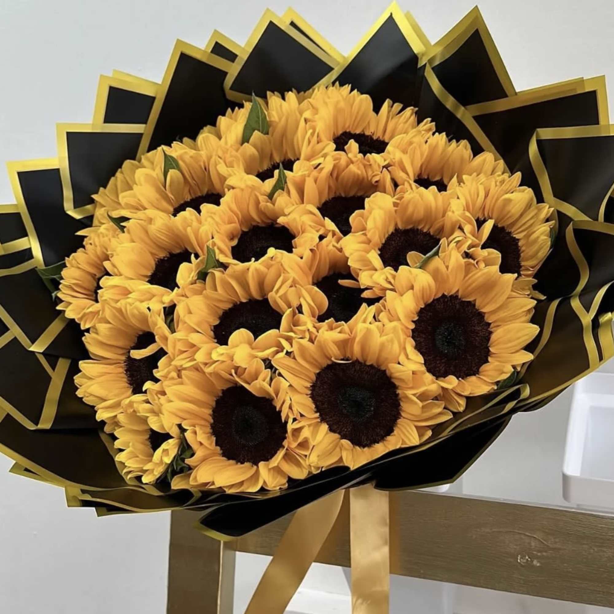 Bouquet of sunflowers wrapped in black and gold paper