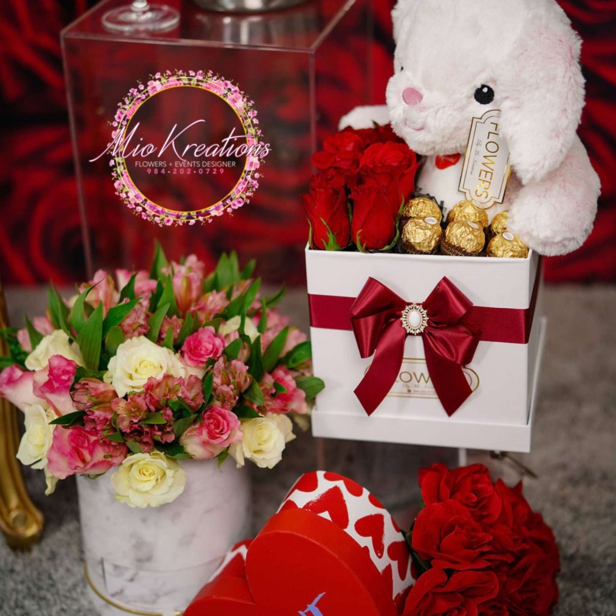 Gift set with red roses, a plush bunny, and chocolates beside a heart box