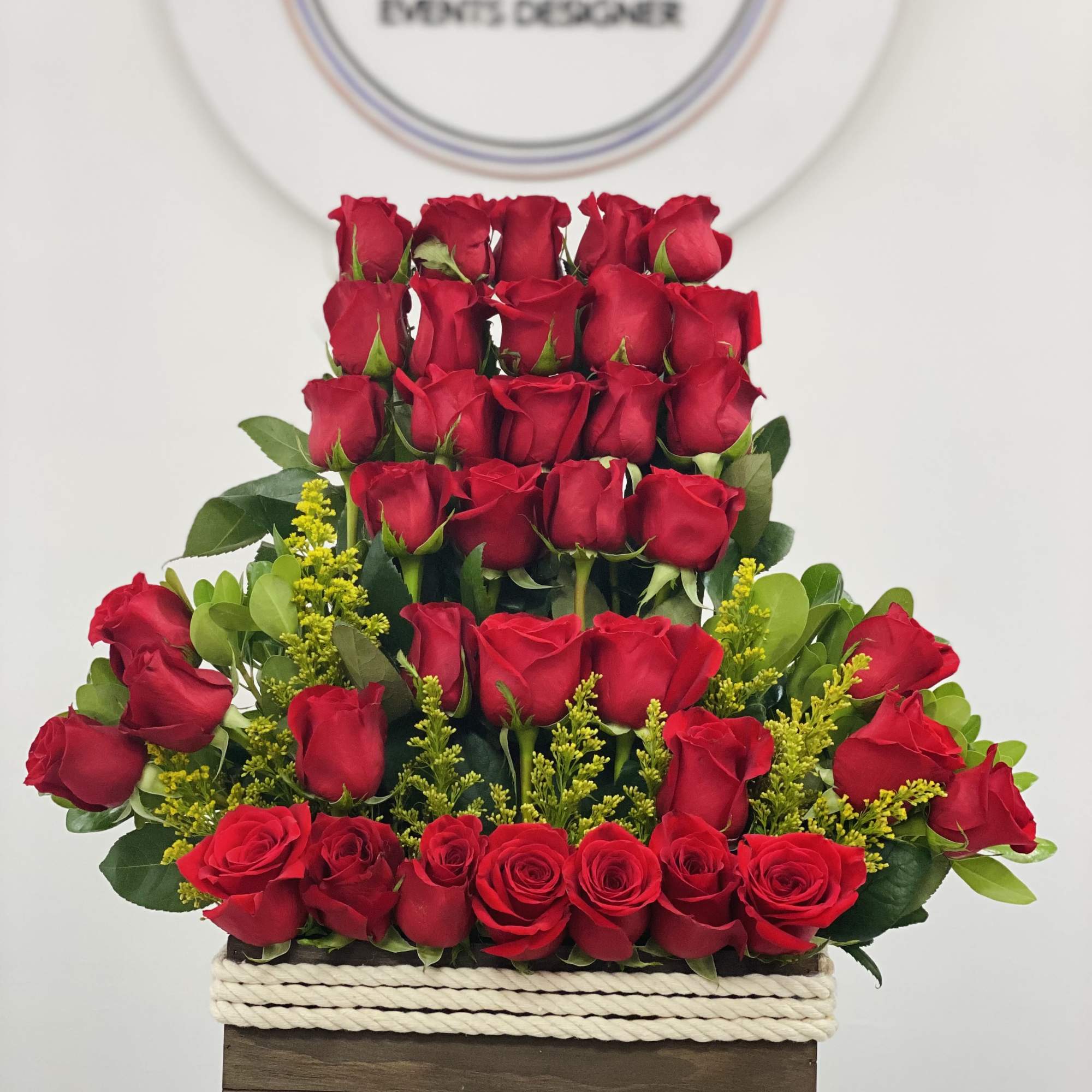 Tiered red rose arrangement in a wooden box