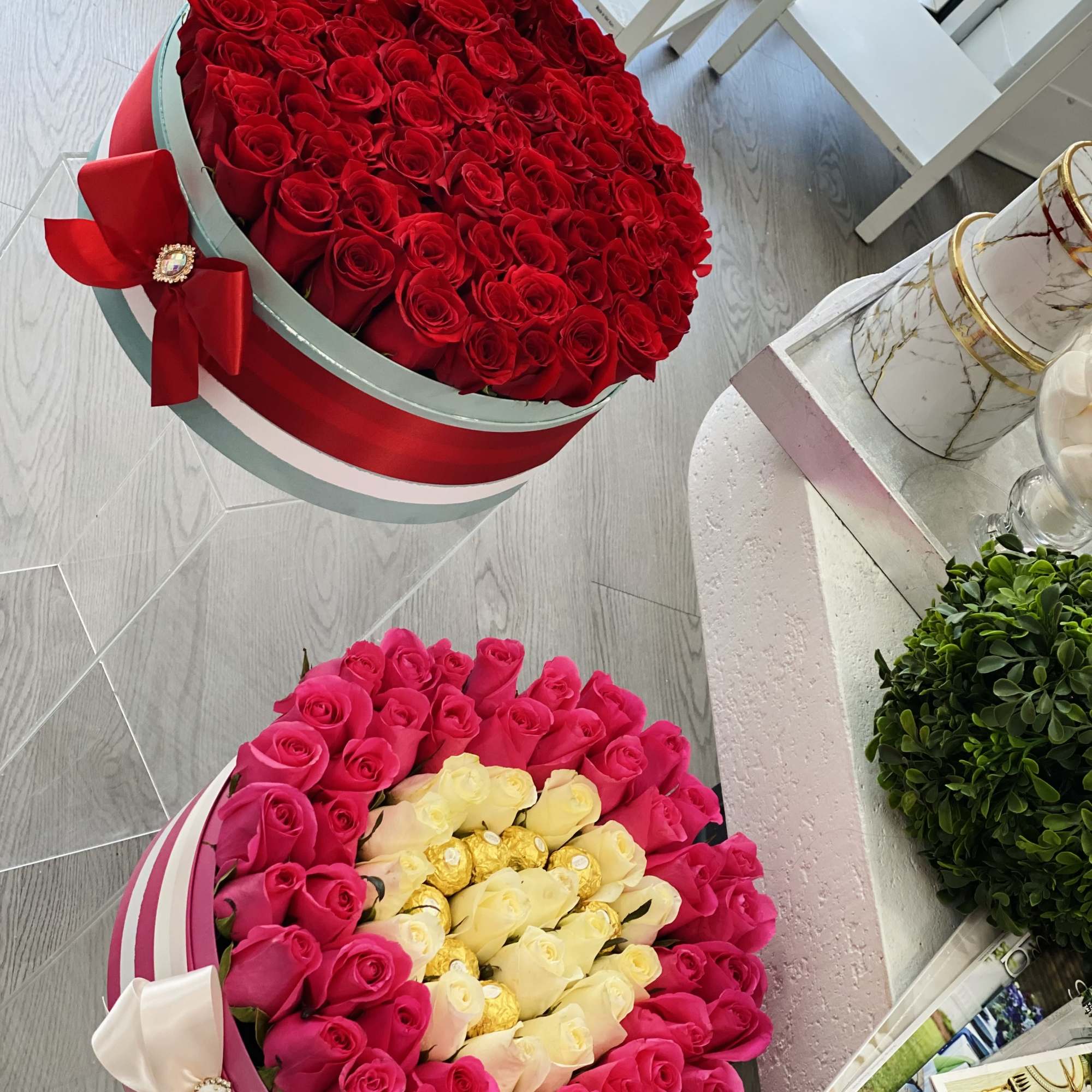 Two round boxes of roses, one red and one pink with cream center roses