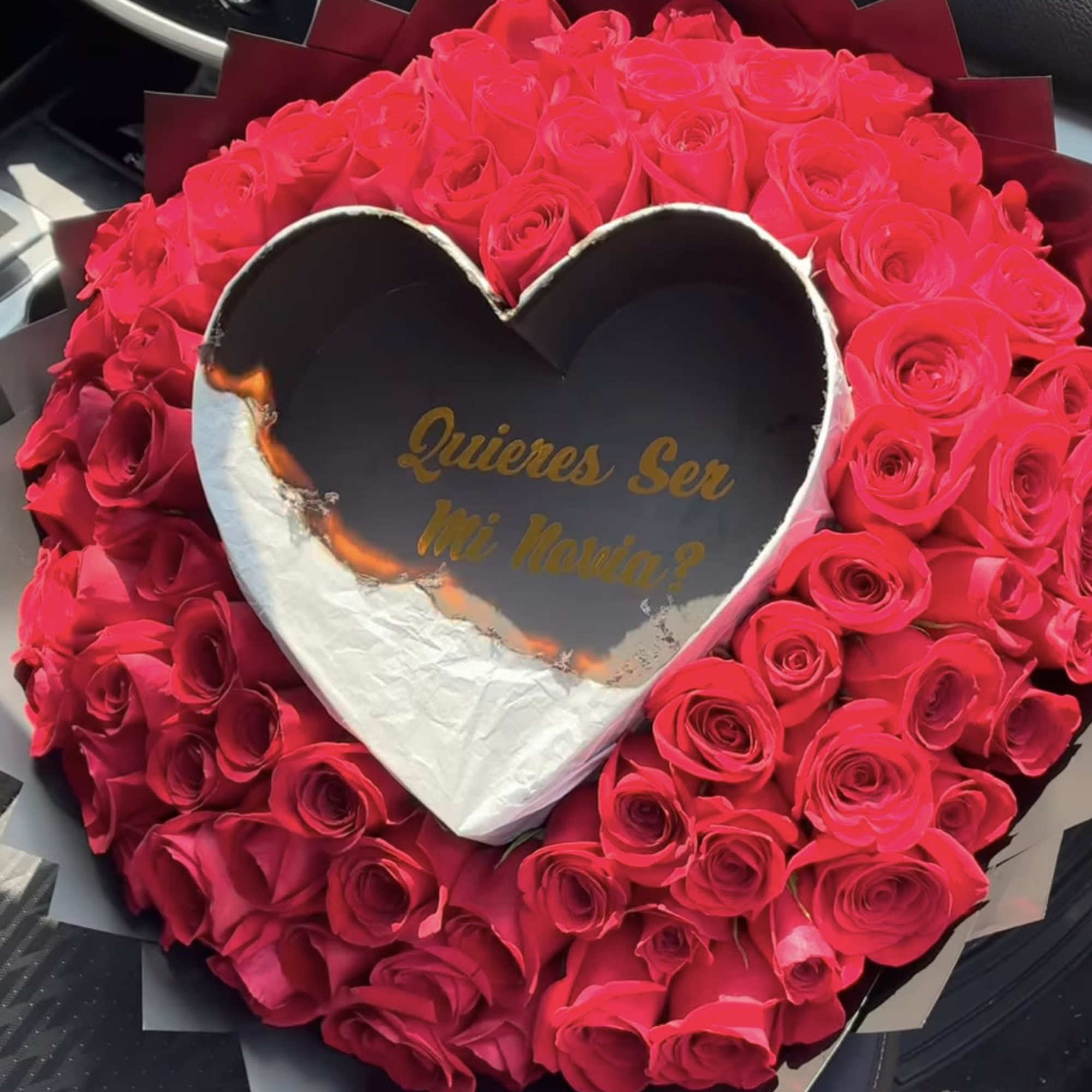 Heart-shaped bouquet of red roses with a central heart card