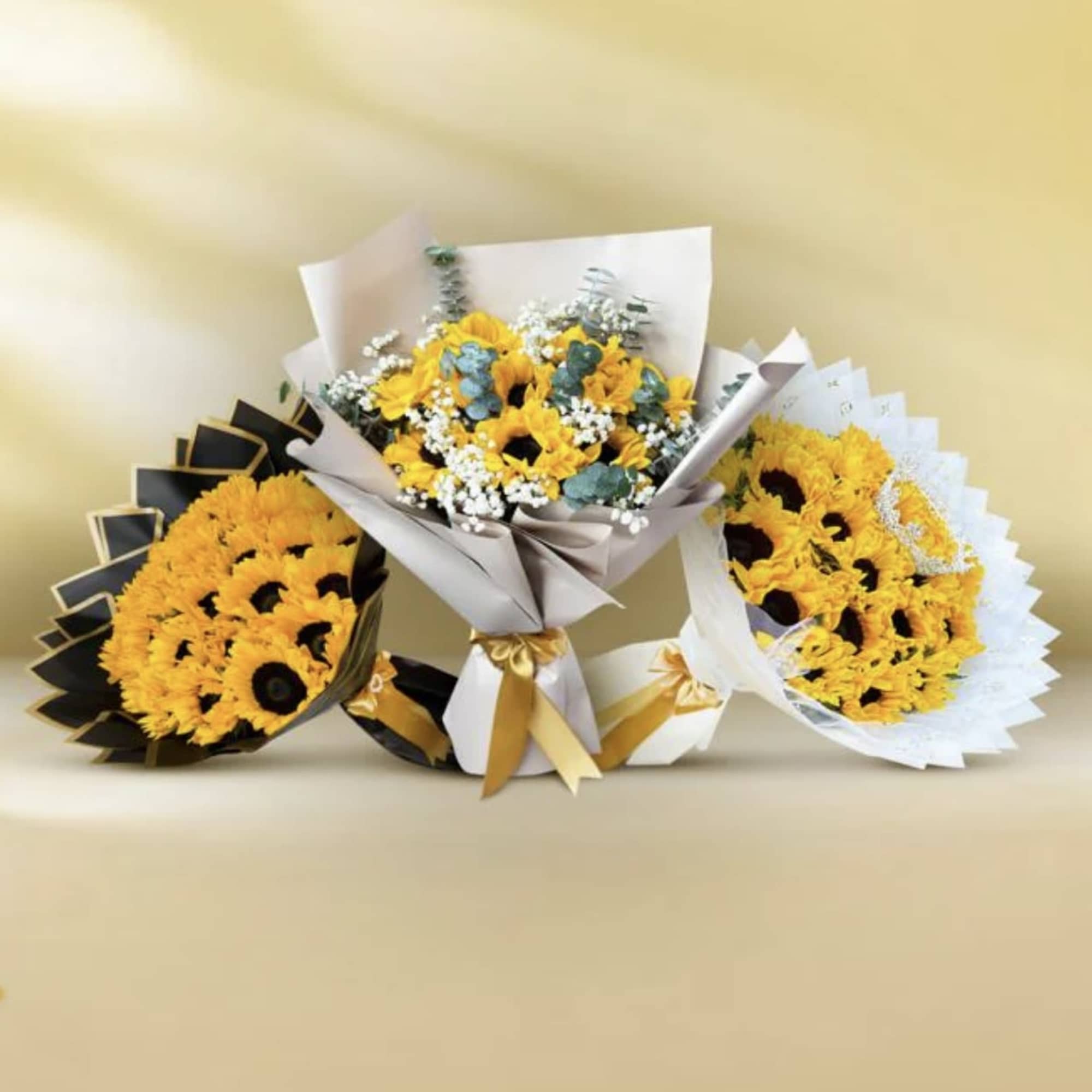 Three sunflower bouquets with mixed filler flowers and wrapped paper