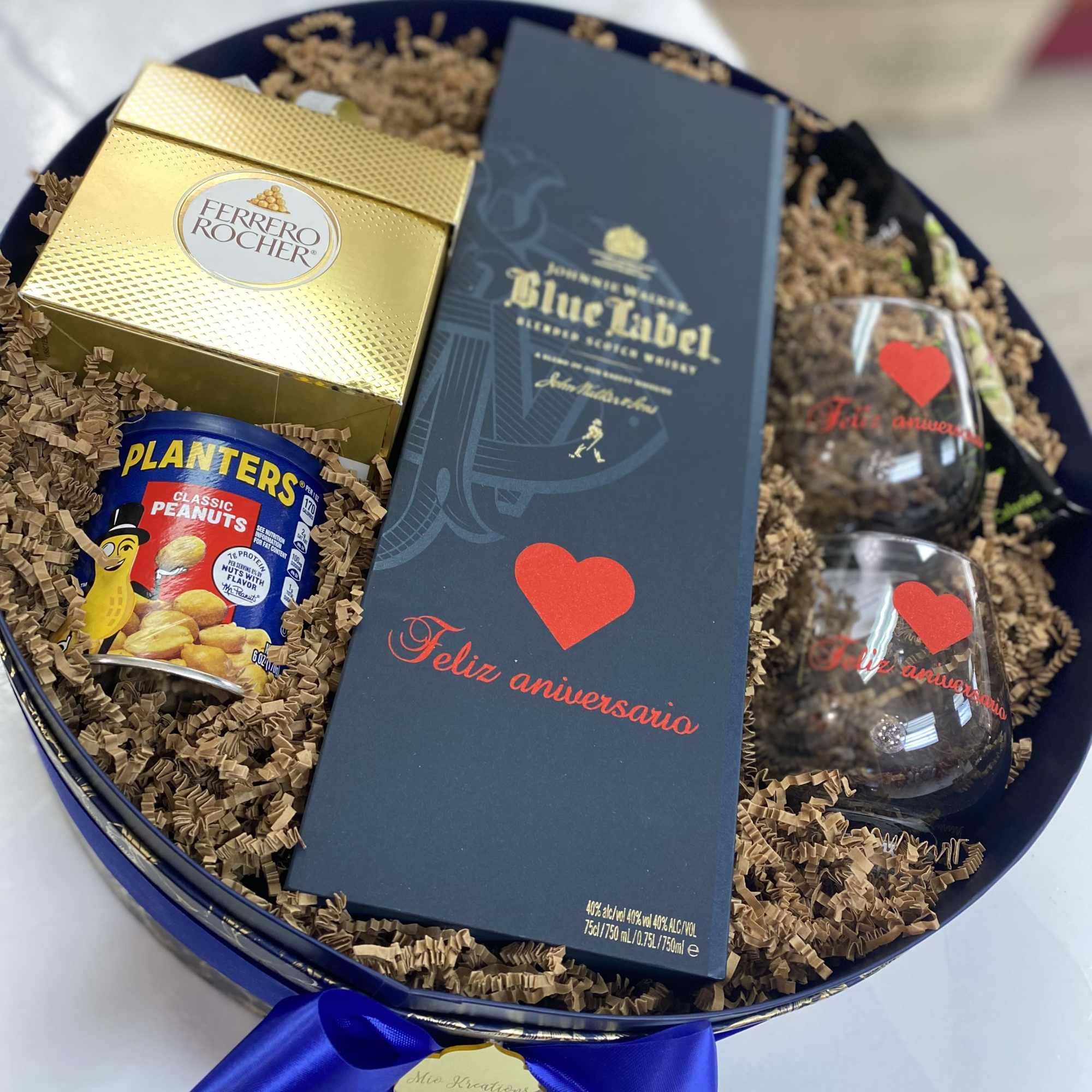 Gift tray with chocolates, peanuts, and wine bottles in a blue box